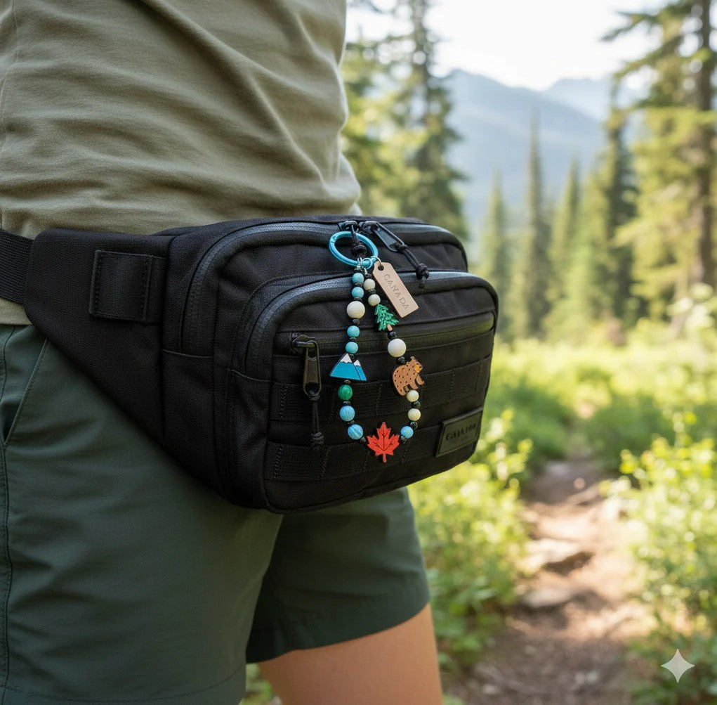 A person with a black waist pack and Northern Icons Maple Mountain Day Bag Charm walks in a forested setting.