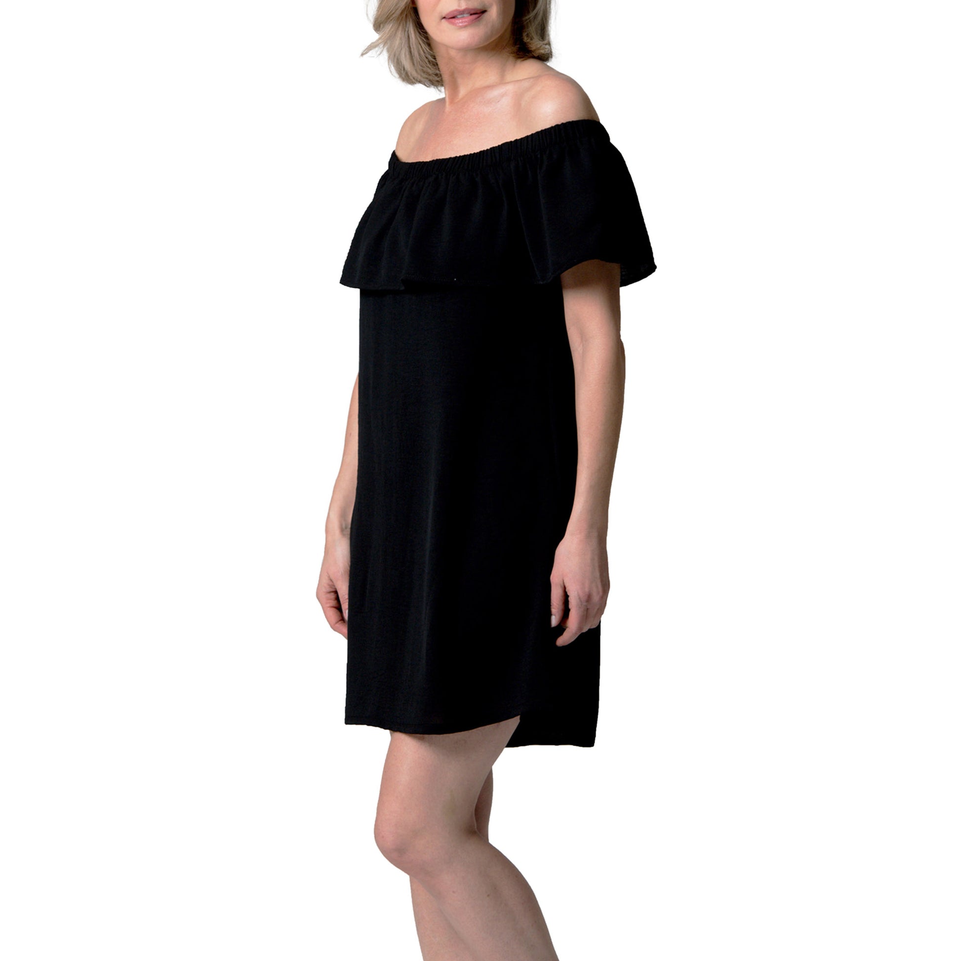 A woman wears the Cover Me Short Frill Airflo Cover Up in black, standing against a plain white background.