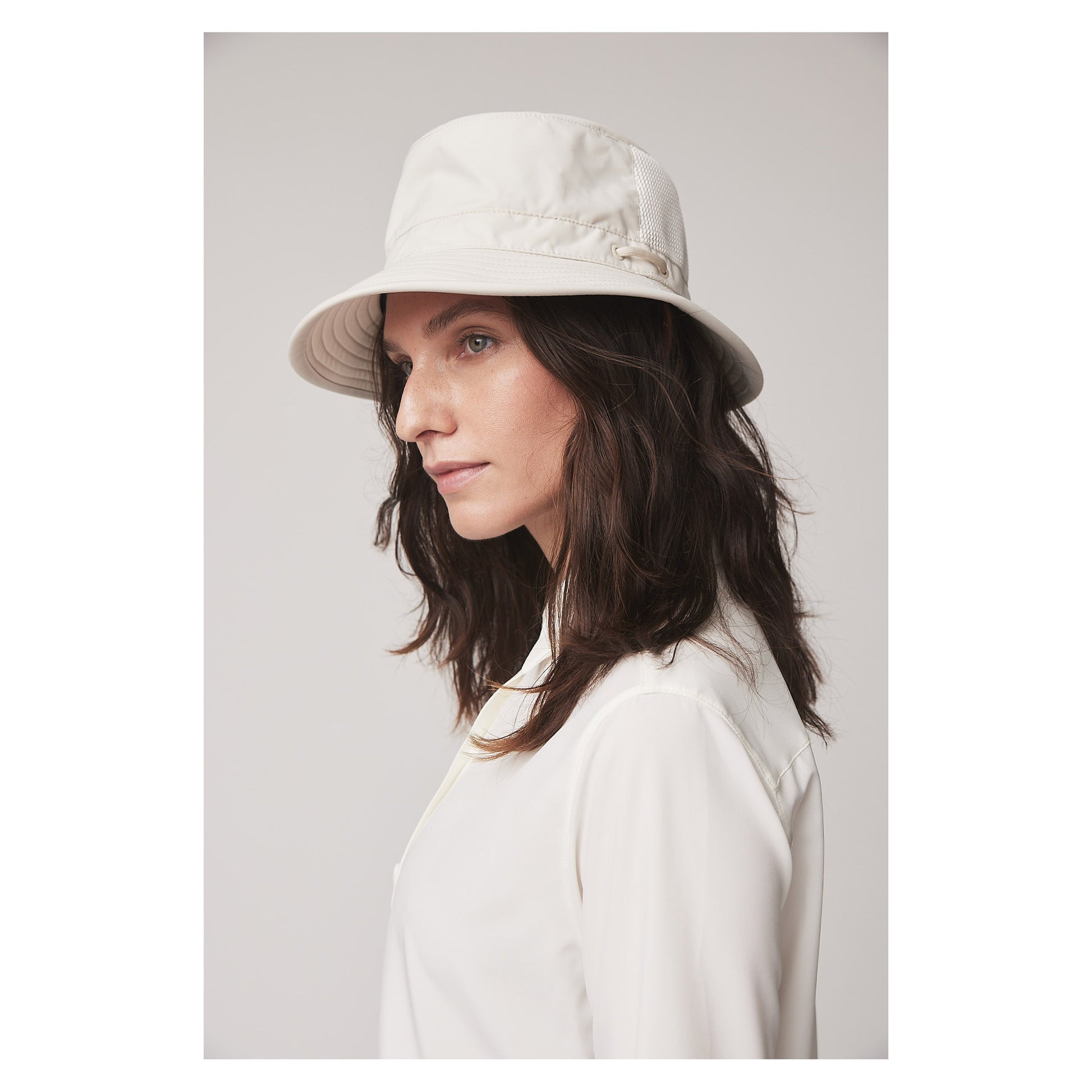 Woman in a white shirt and Tilley LTM1 Airflo® Bucket Hat, shown in profile against a plain background.