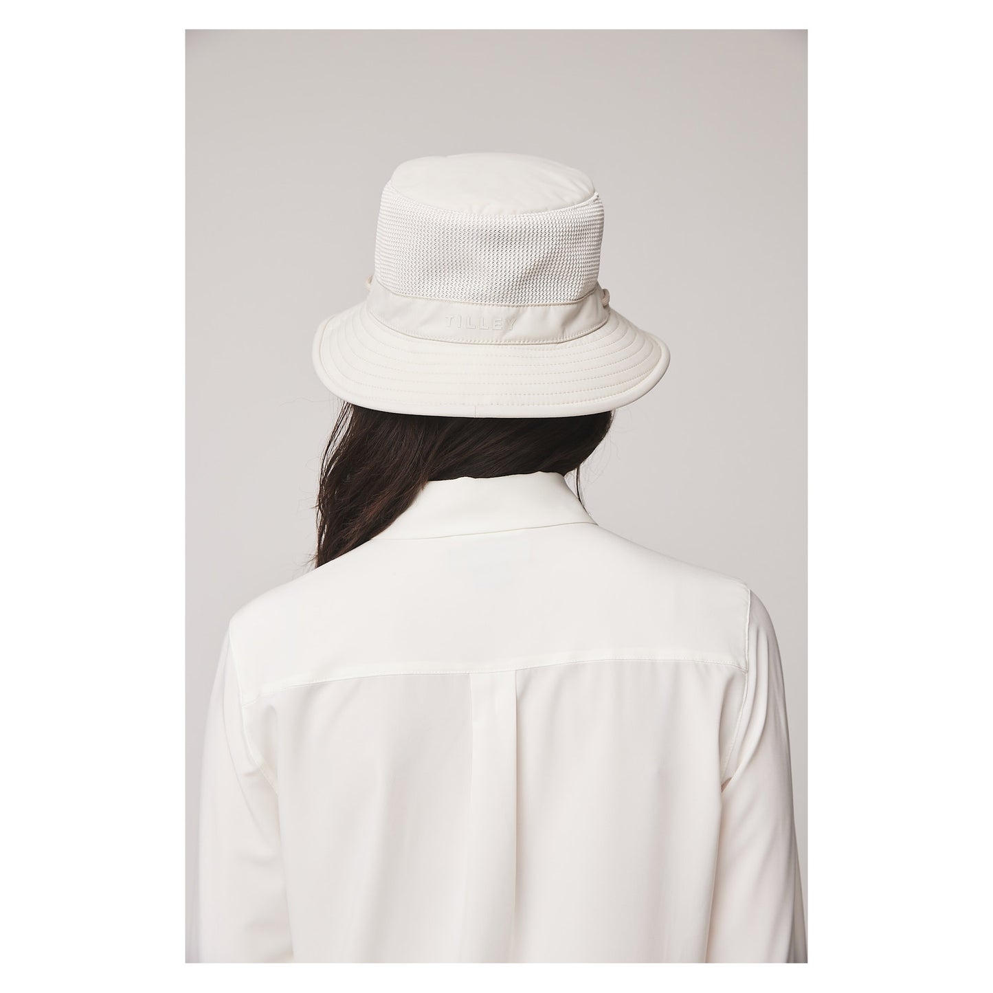 Person wearing a Tilley LTM1 Airflo® Bucket Hat and a white collared shirt, shown from the back.