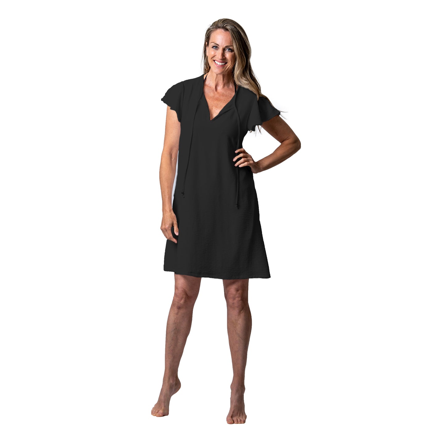 Woman barefoot, smiling in a black Cover Me Short Airflo Tunic against a white background.
