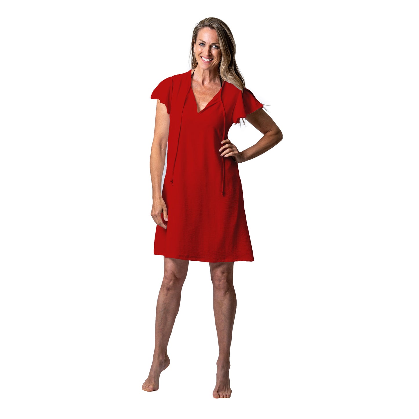 Barefoot woman in a terracotta red Cover Me Short Airflo Tunic smiling at the camera.