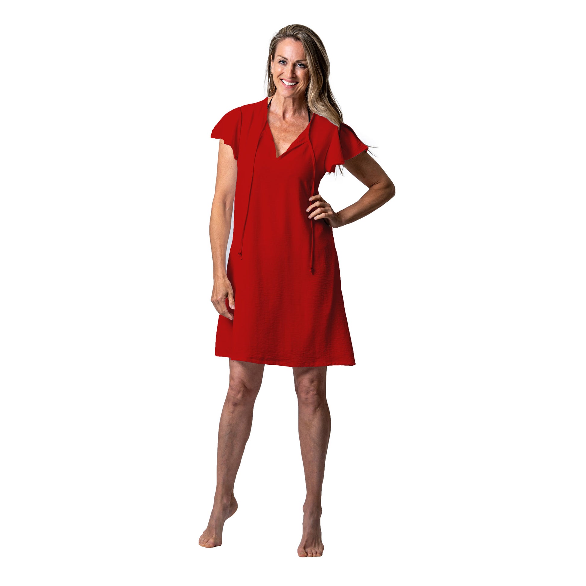 Barefoot woman in a terracotta red Cover Me Short Airflo Tunic smiling at the camera.