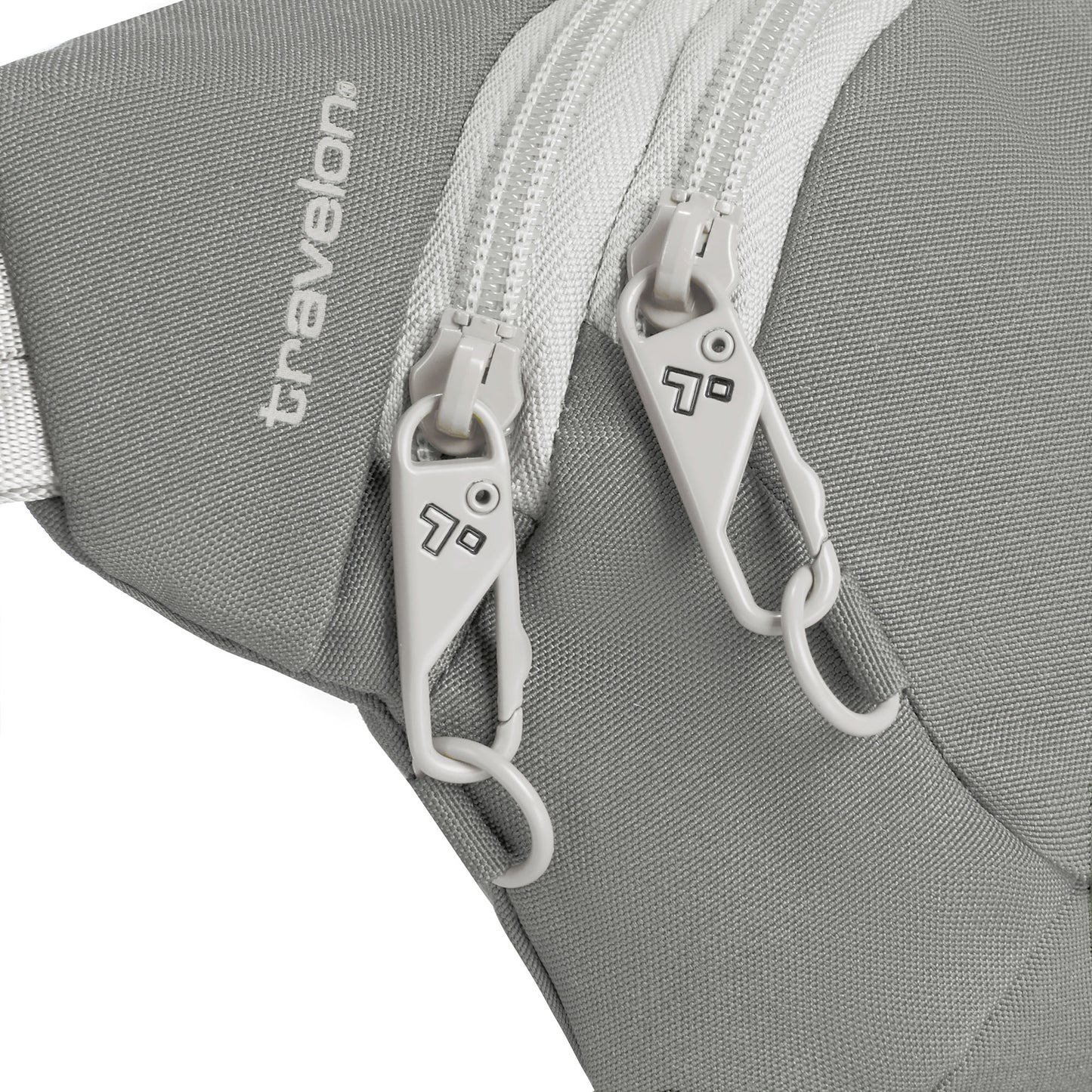 Close-up of two white lockable zippers on a granite grey Travelon Voyages Anti-Theft Waist Pack with the "Travelon" logo.