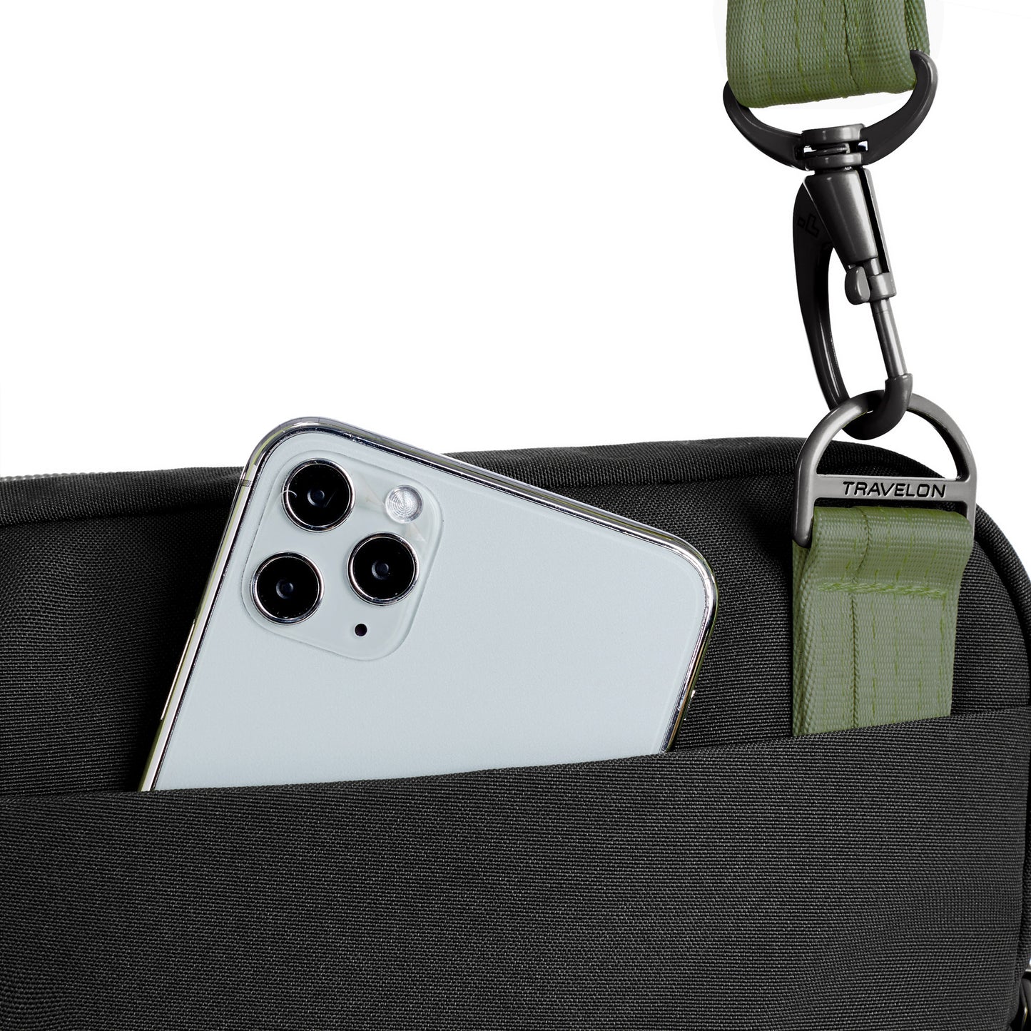A smartphone sticks out of a black Travelon Voyages Anti-Theft Slim Bag featuring a green strap.