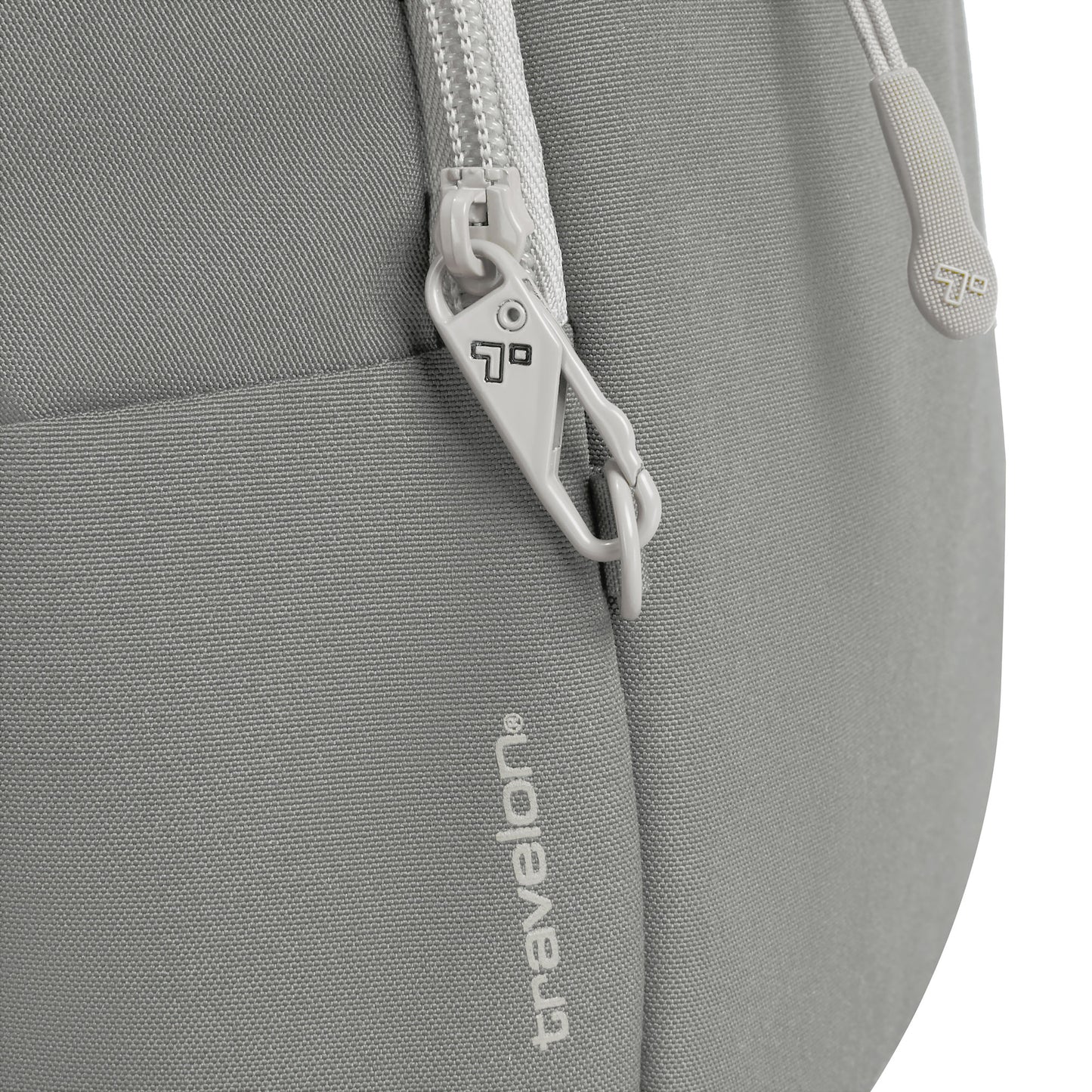 Close-up of a grey Travelon Voyages Anti-Theft Tour Bag with a lockable zipper and logo branding.