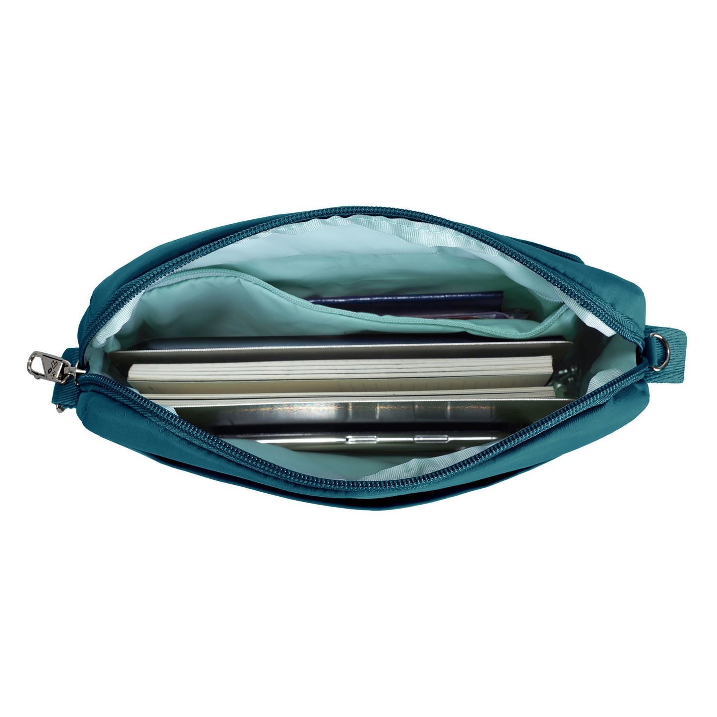 Open the capri blue Travelon Roam Anti-theft Crossbody showing notes, a pen, and an inner zippered pouch.
