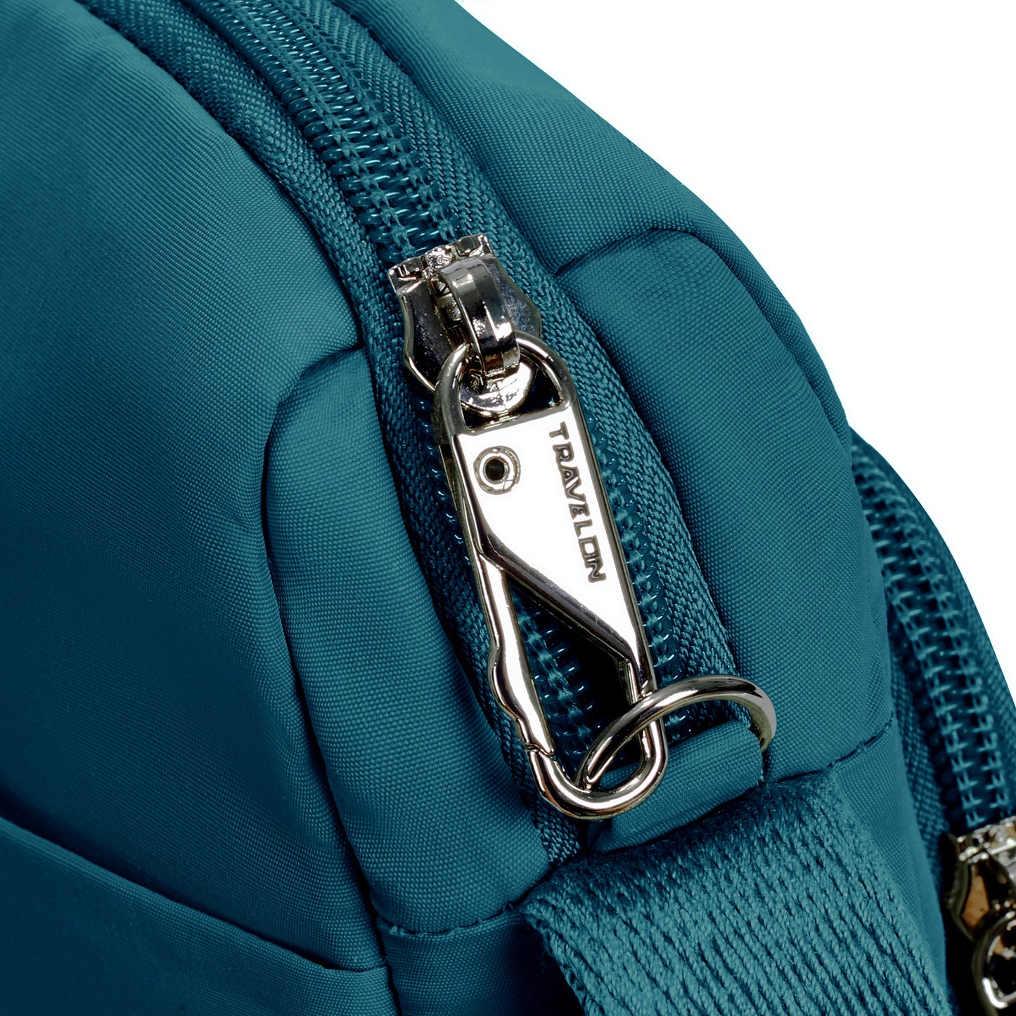 Close-up of a capri blue Travelon Roam Anti-theft East/West Crossbody with silver zipper lock and anti-theft clip.