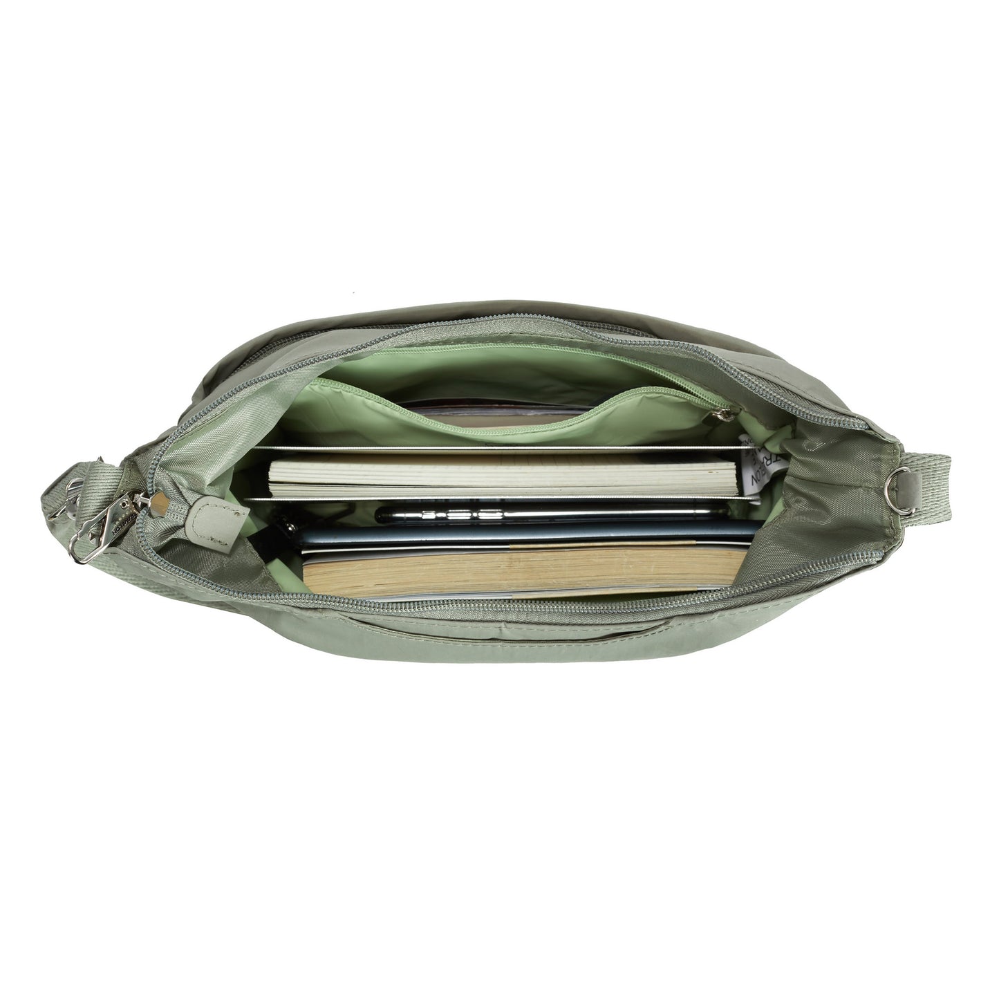 Travelon Roam Anti-theft Medium Crossbody with books, a notebook, and a pen inside.