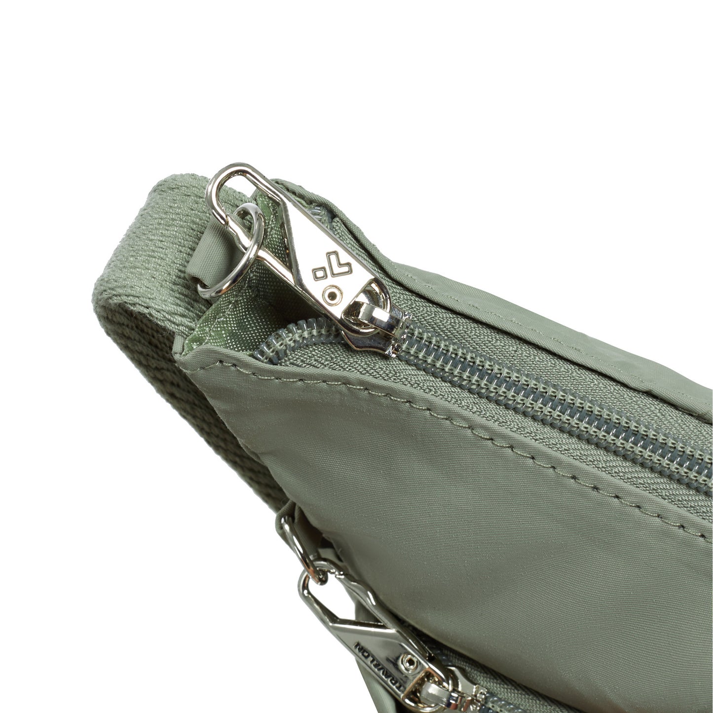 Close-up of Travelon Roam Anti-theft green crossbody bag with metal zipper and silver pull.