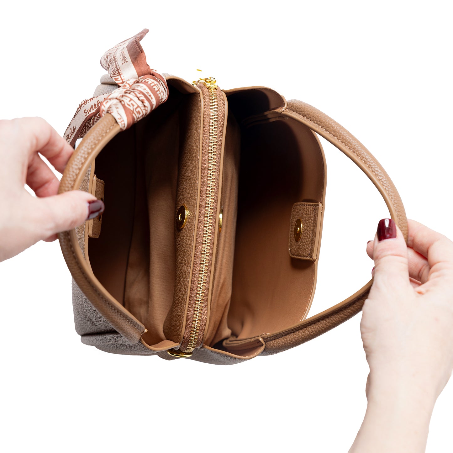 Hands holding a tan colour Miss Caprice Abby Tote with two compartments and central zipper compartment.