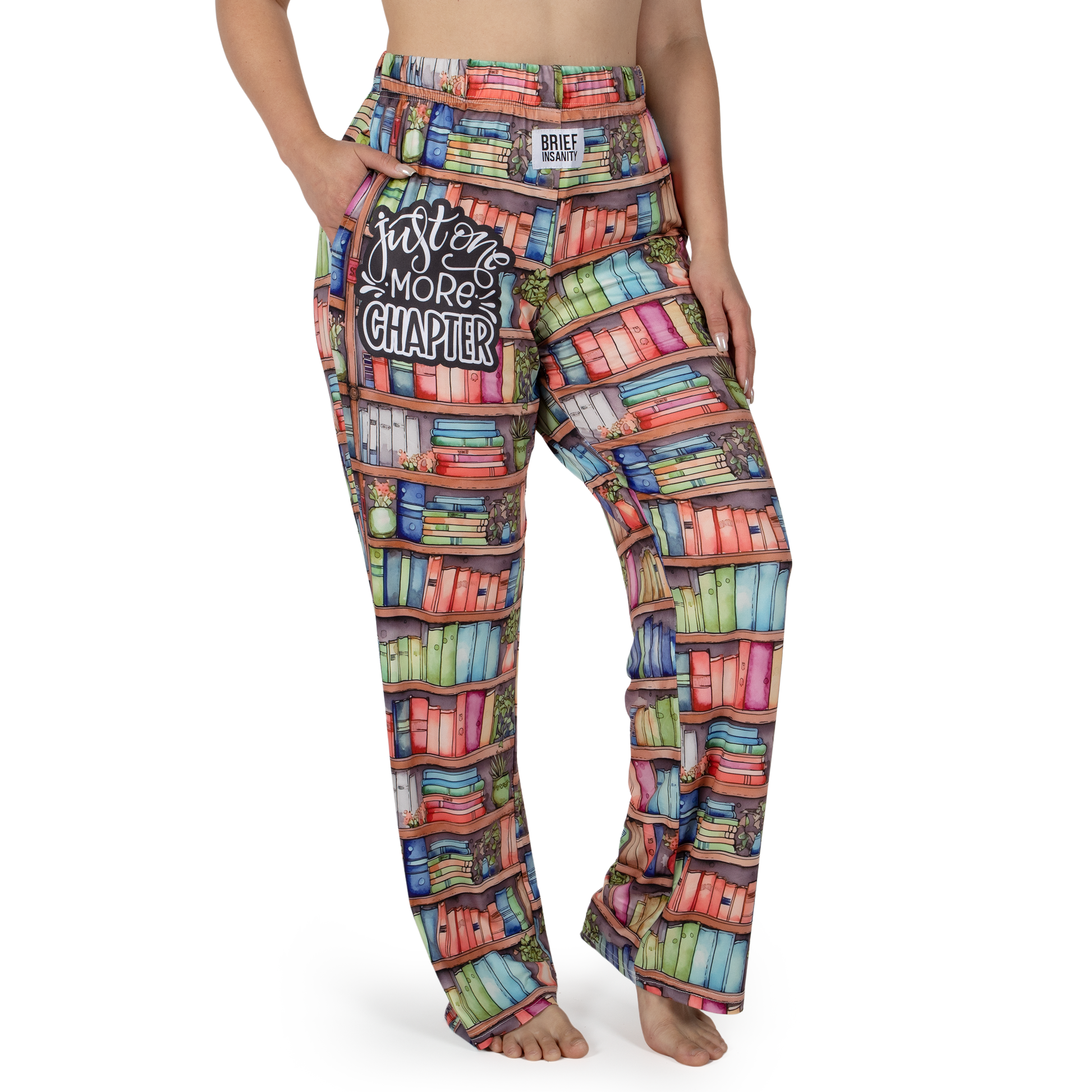 Wearing Brief Insanity Lounge Pants: colorful bookshelf print with "Just One More Chapter" on the pocket.