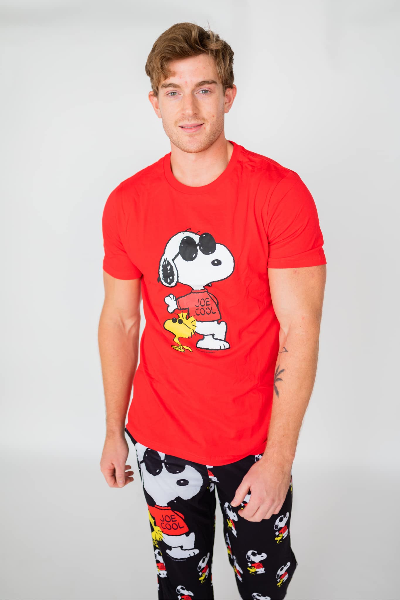Man wears Brief Insanity T-Shirt - Peanuts Snoopy Joe Cool with matching black pajama pants, on a white background.