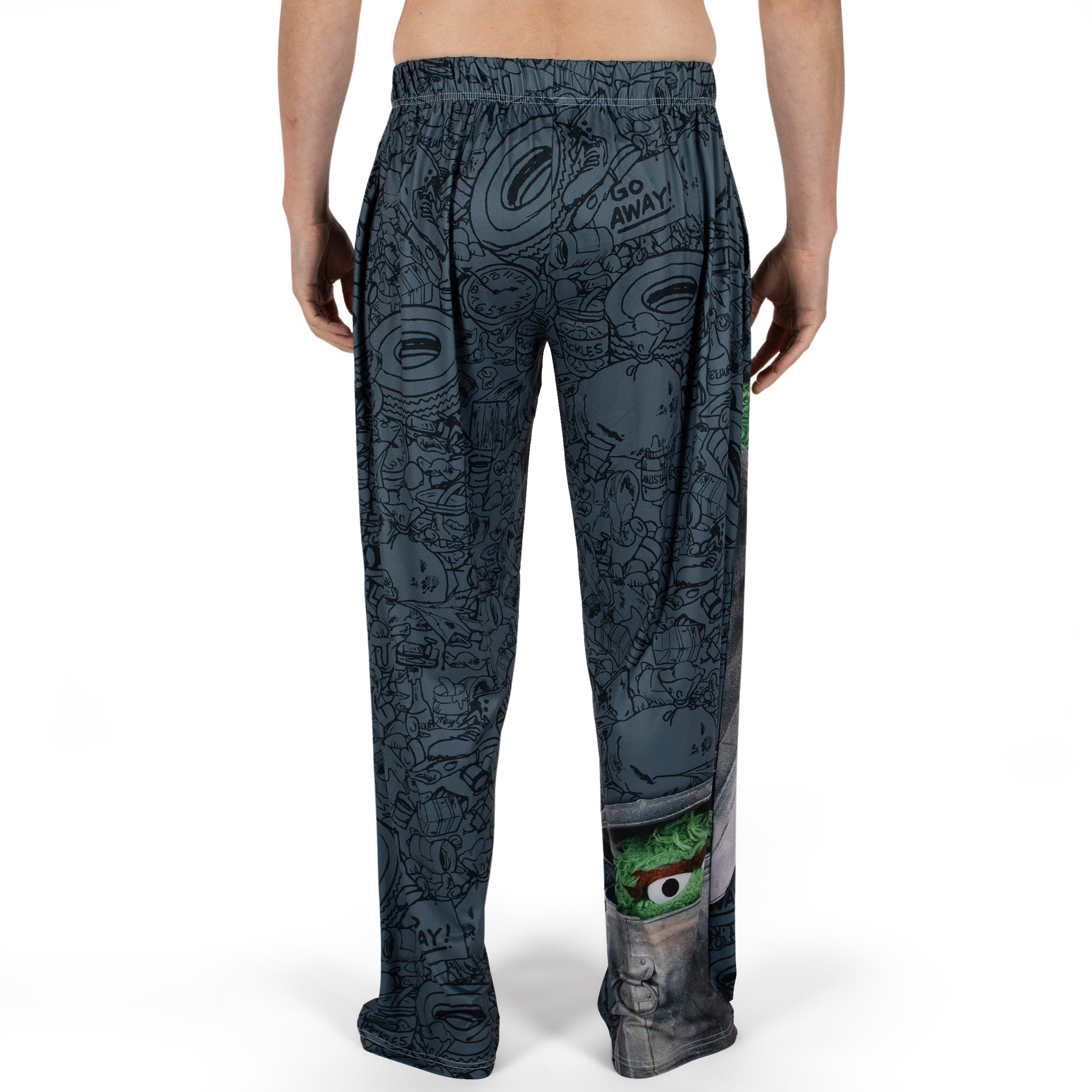 Person wears Brief Insanity Sesame Street Grouchy lounge pants with Oscar The Grouch and "GO AWAY!" graphics.