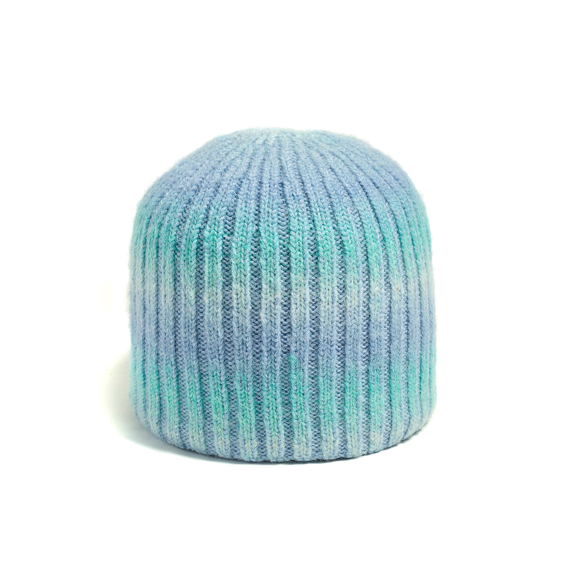 The Brume Cascade Mountain Reversible Hat is a ribbed knit beanie in blue, green, and white on a white background.