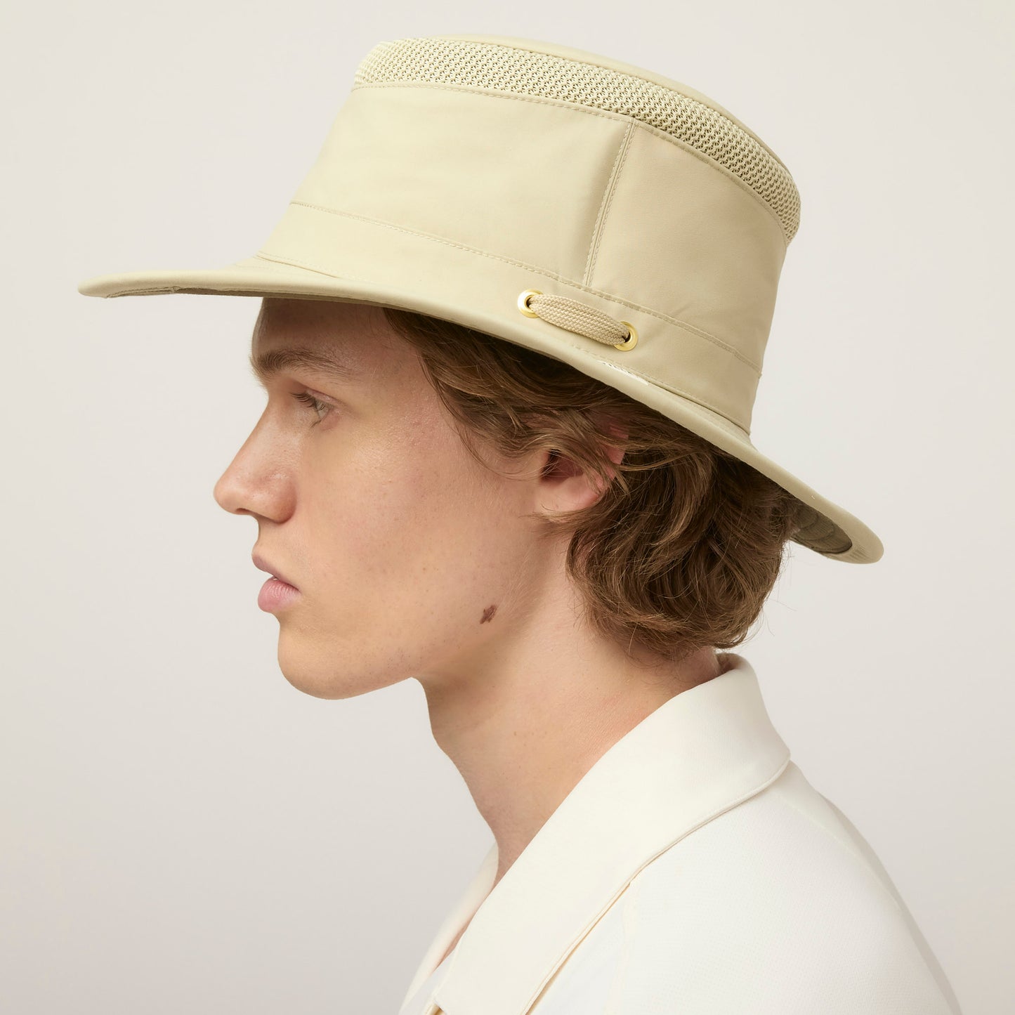 A person in profile wears a Tilley LTM5 Airflo® Hat and collared shirt against a plain background.