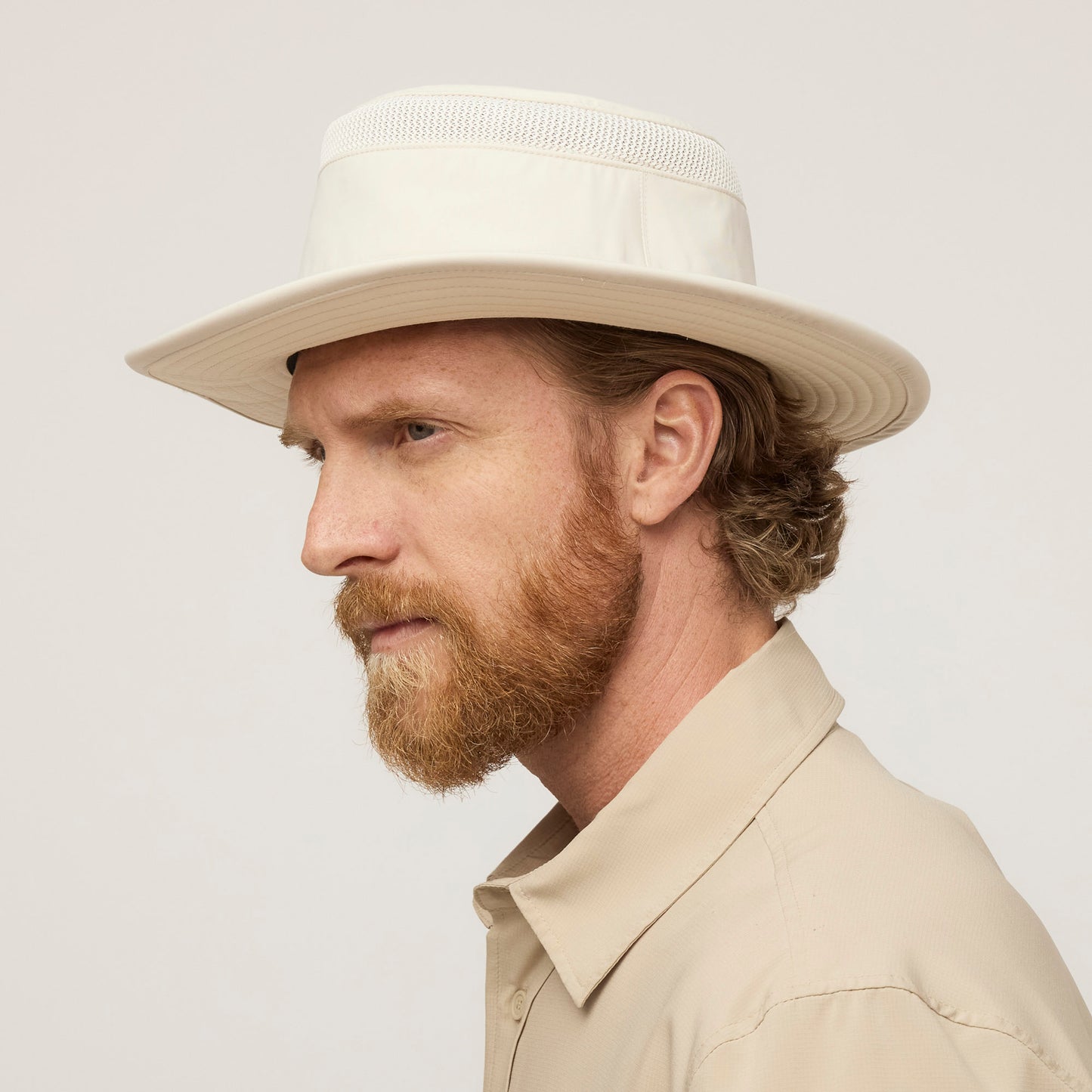 A bearded man in profile wears a Tilley Airflo® Boonie Hat and a UPF 50+ sun-protective shirt.