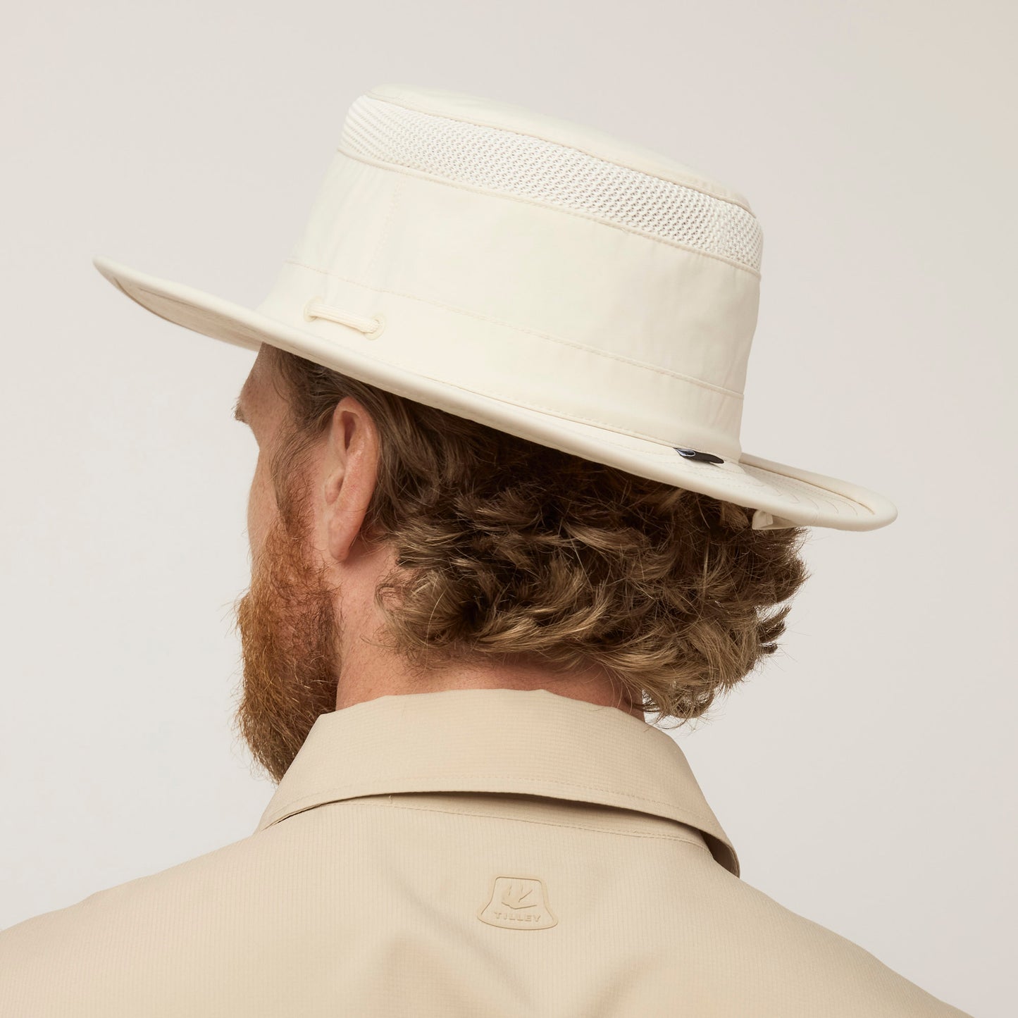 Man with curly hair shown from behind wearing the Tilley Airflo® Boonie Hat with UPF 50+ sun protection.