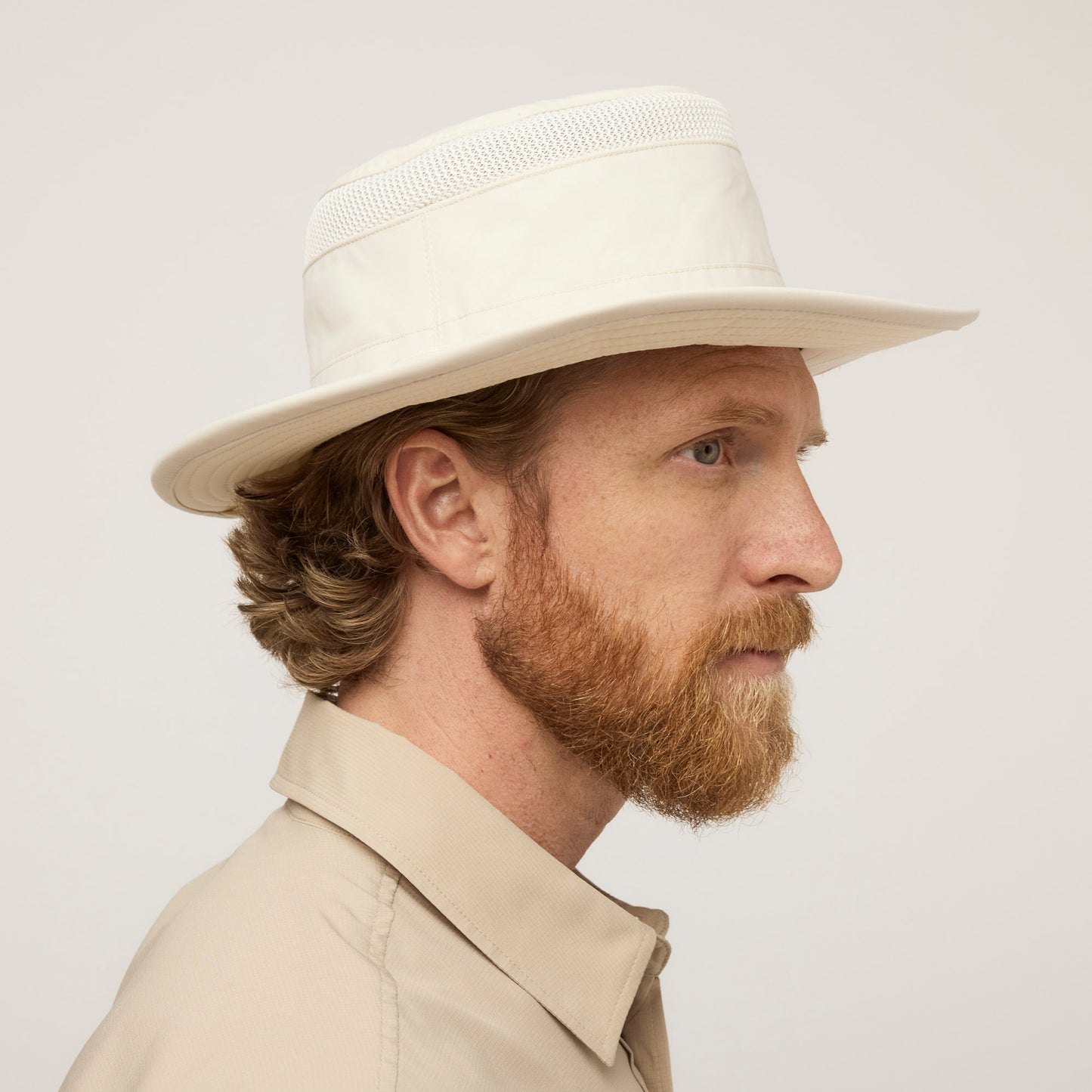 A man in side profile wears the Tilley Airflo® Boonie Hat, featuring UPF 50+ sun protection by Tilley.