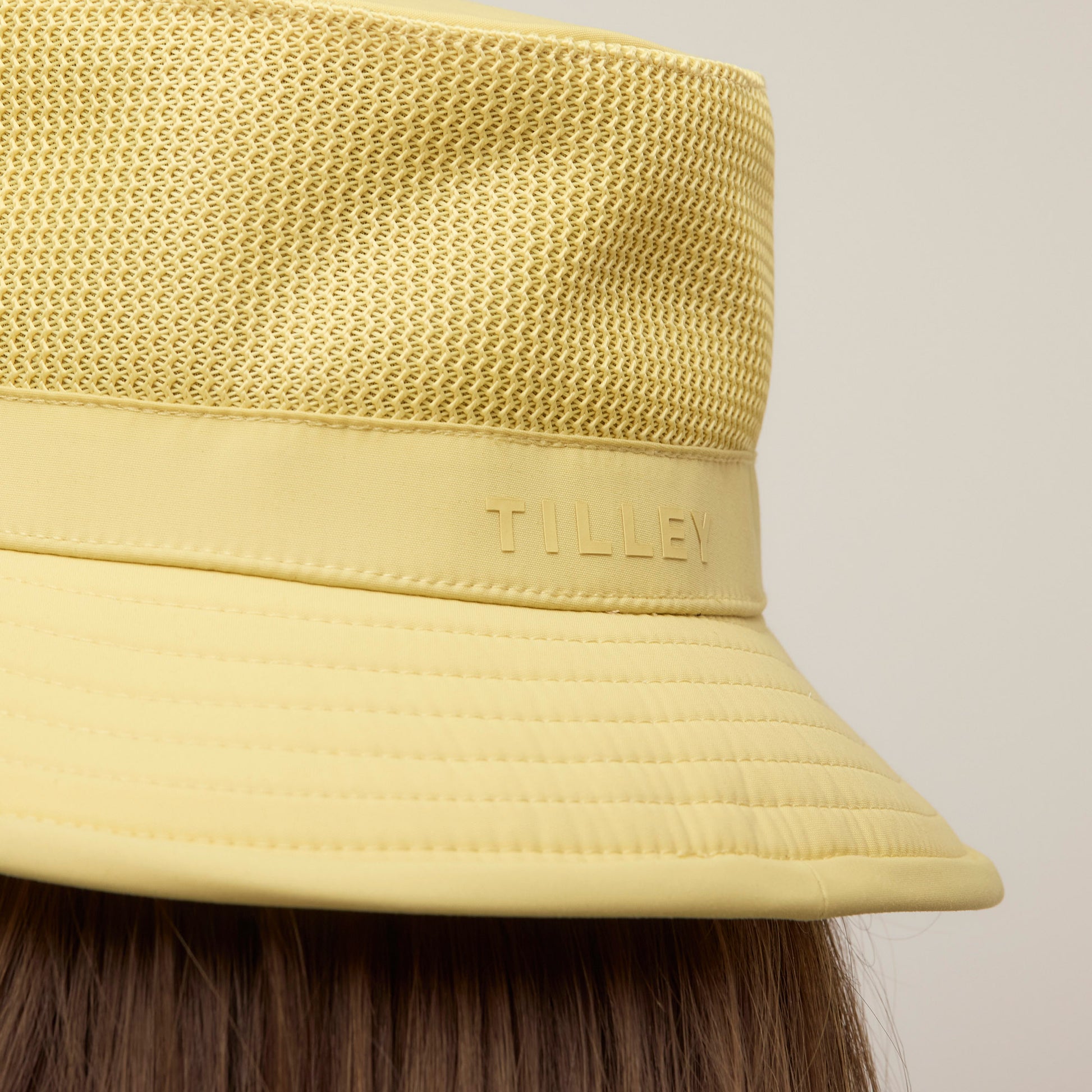 Tilley LTM1 Airflo® Bucket Hat in yellow, mesh crown detail, Tilley brand, shown from the back on brown hair.