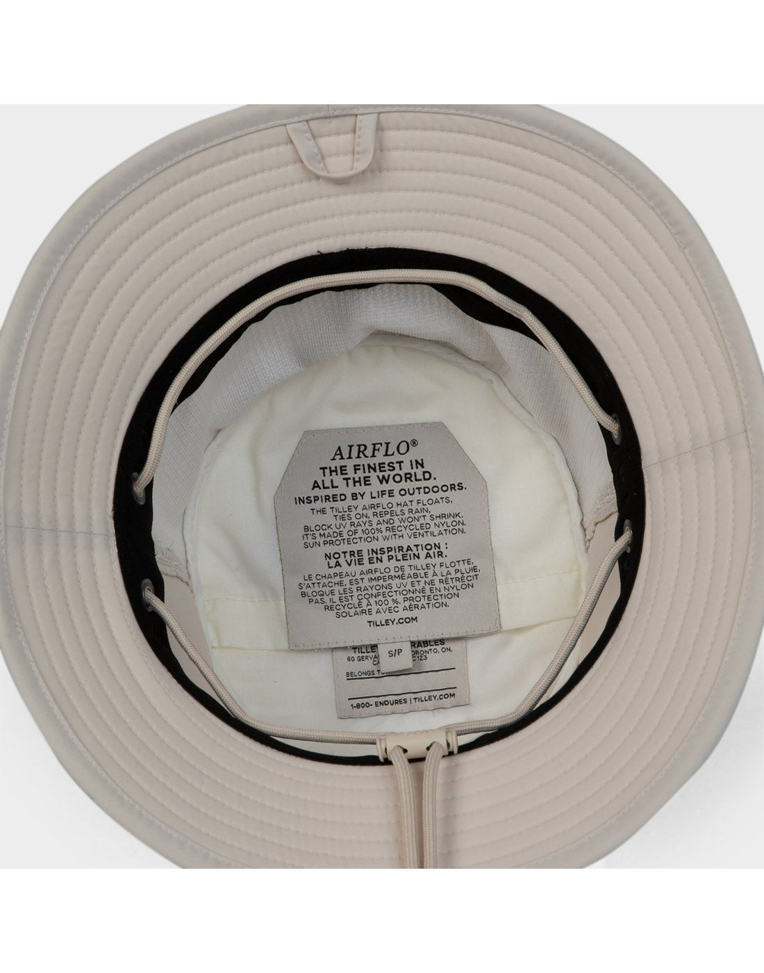 Tilley LTM1 Airflo® Bucket Hat by Tilley shown inside out, displaying inner tags and recycled nylon material.