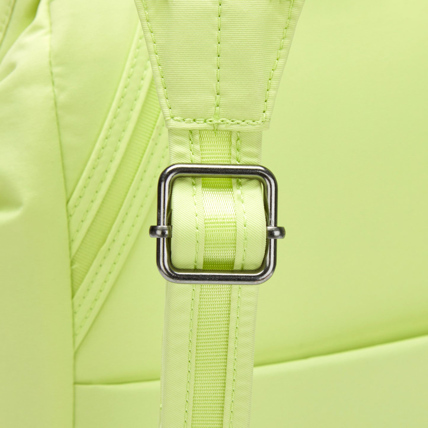 Close-up of an adjustable strap on the matcha green Pacsafe® CX Anti-theft 17L Backpack, made from ECONYL nylon.