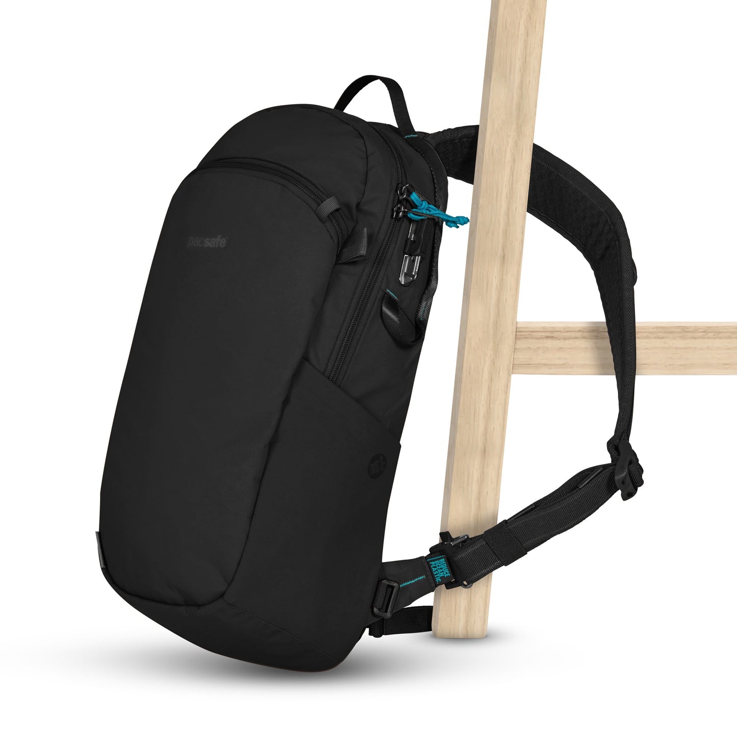 The Pacsafe® ECO 12L Anti-theft Sling Backpack hangs on a chair, made with recycled materials and adjustable straps.