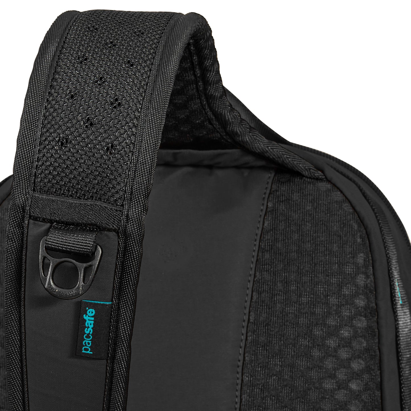 Close-up of a black Pacsafe® ECO 12L sling backpack strap with teal label, silver ring, and recycled materials.
