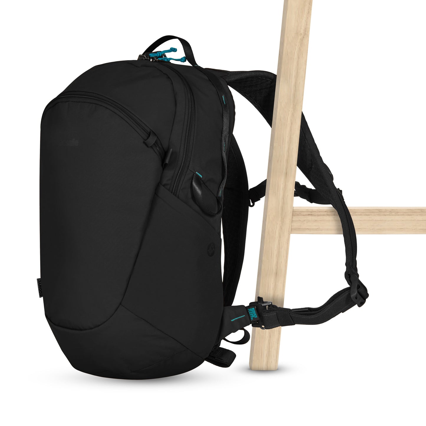 Pacsafe® ECO 18L Anti-theft Backpack features turquoise zippers, made from ECONYL®, clipped to a wooden chair.