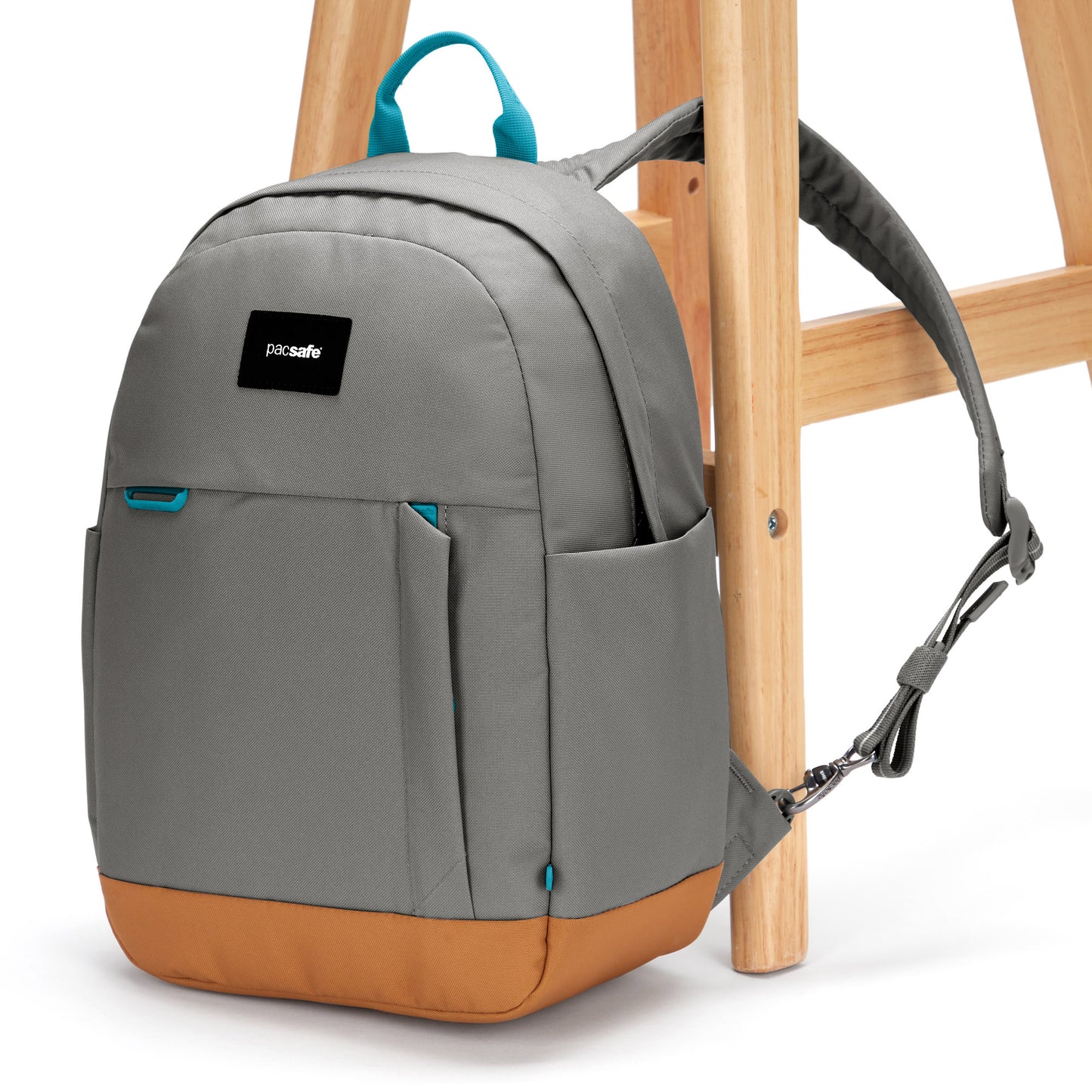 Pacsafe® Go 15L Anti-theft Backpack, stone with tan bottom gusset, attached to a chair leg