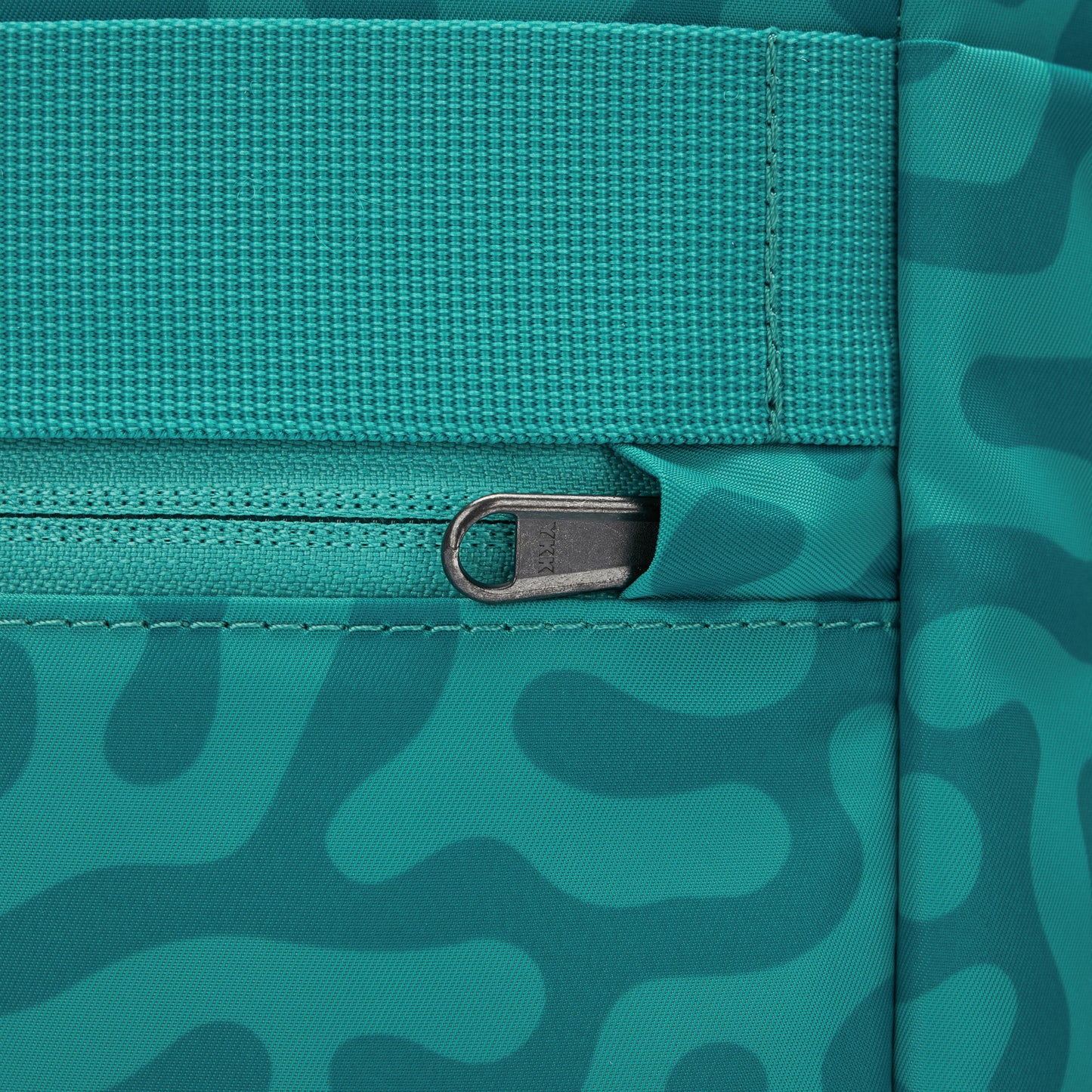 Close up of security pocket on back with tucked zipper pull for added security.