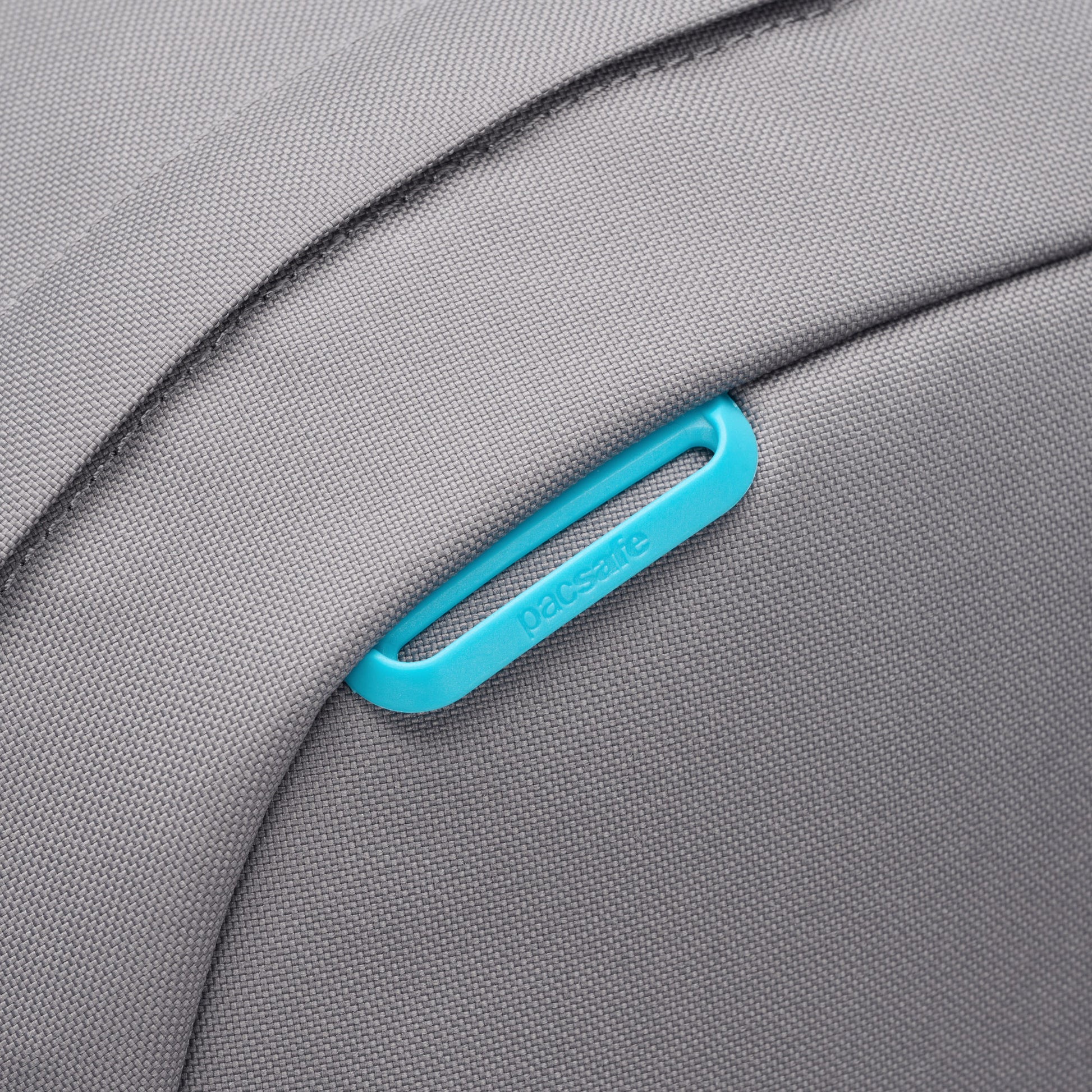Close up of turquoise lashing point on top front of stone Pacsafe® GO 25L Anti-theft Backpack