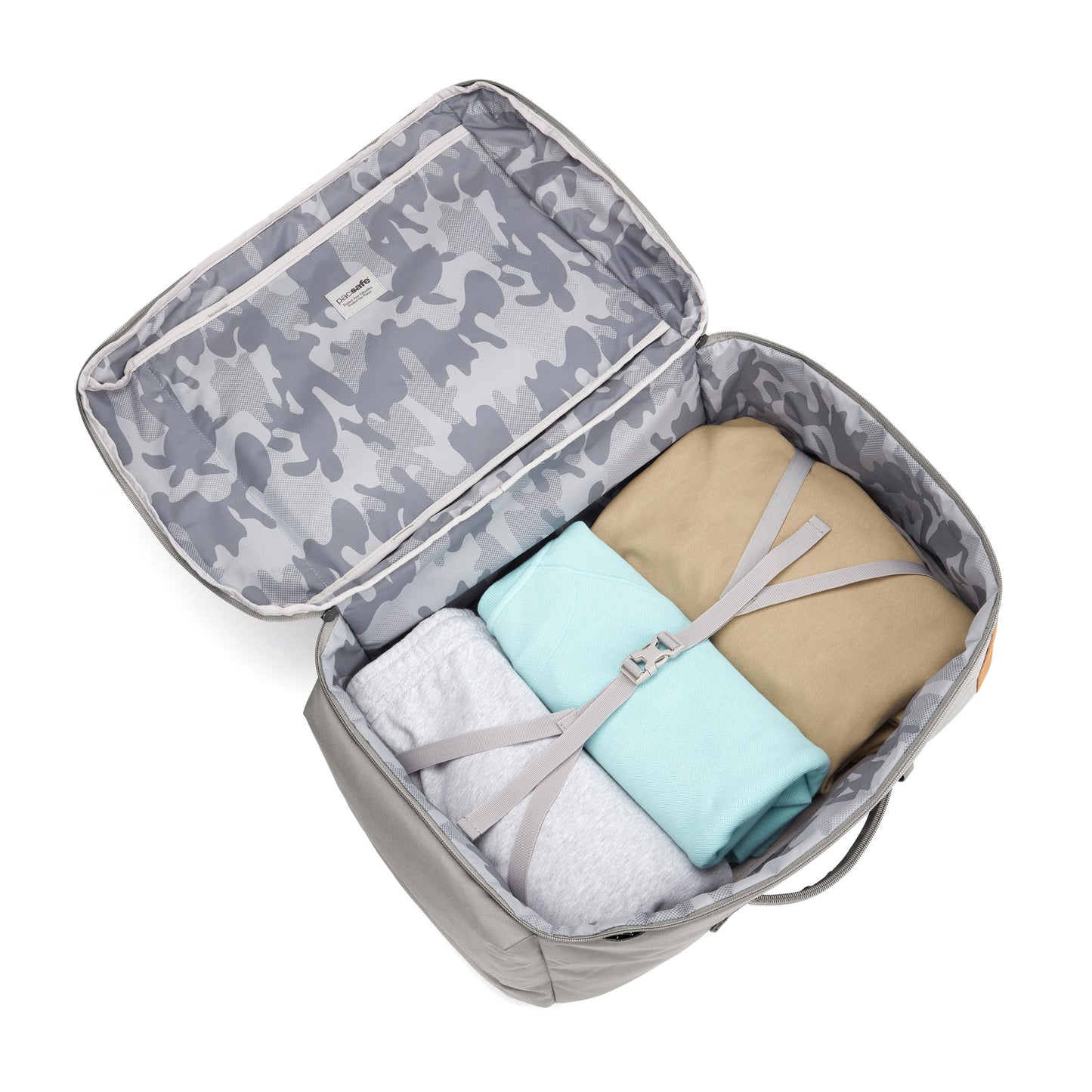 Open Pacsafe GO 44L Backpack with camo lining & recycled polyester; clothes secured by straps.