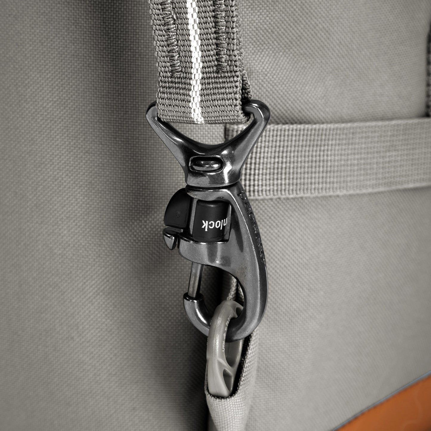 Close-up of a black locking carabiner on the Pacsafe® GO 44L Anti-theft Carry-on Backpack, made from recycled polyester.