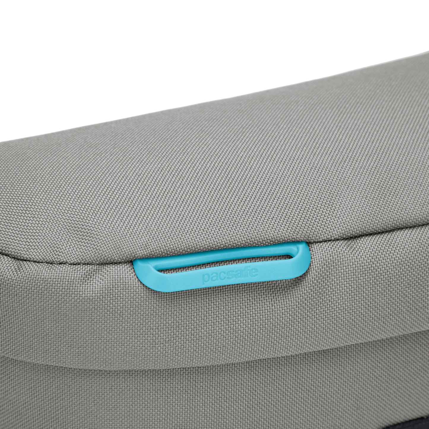 Close up of turquoise key attachment on stone Pacsafe GO Sling Pack