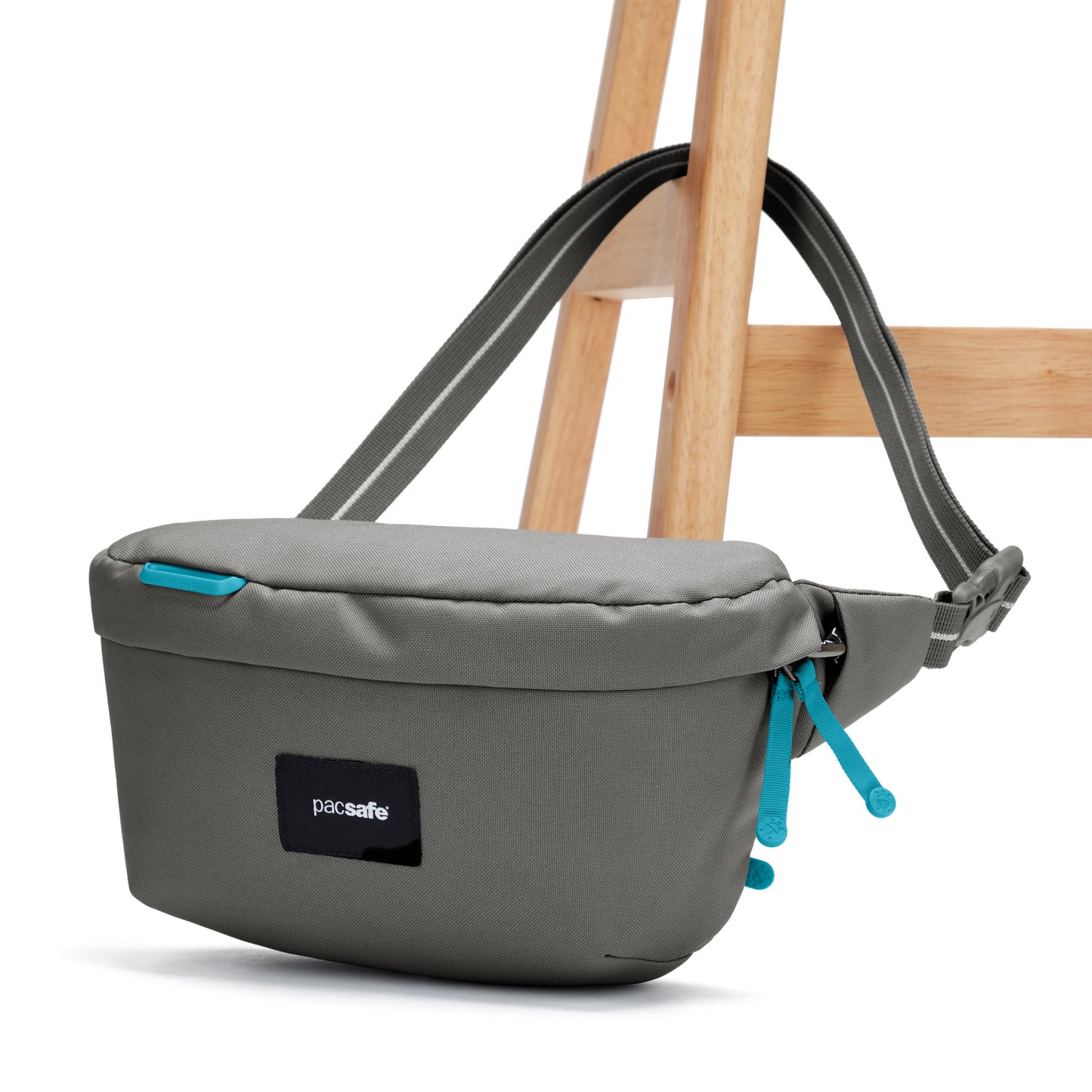 Pacsafe® GO Anti-Theft Sling Pack in stone grey colour attached to chair leg.