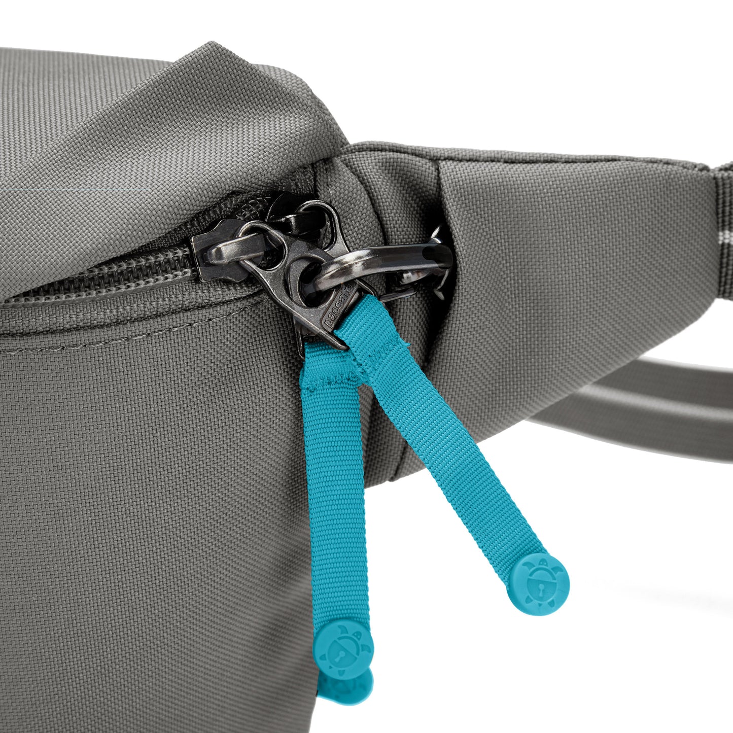 Close up of lockable zipper with turquoise zipper pulls on stone Pacsafe GO Sling Pack