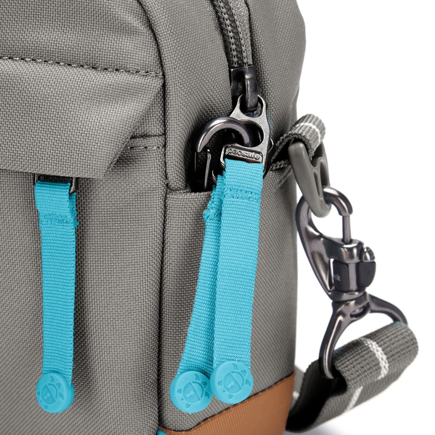 Close up of turquoise zipper pulls on stone Pacsafe® GO Anti-Theft Crossbody Bag
