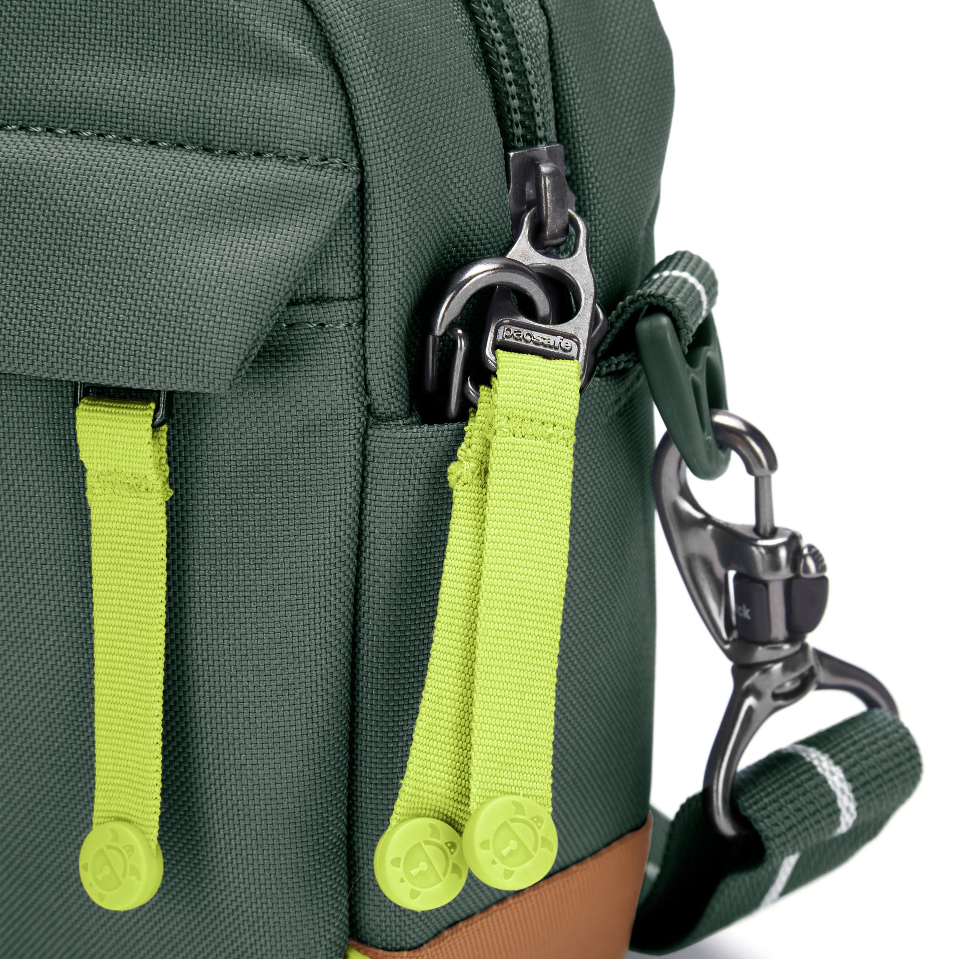 Close up of lime green zipper pulls on spruce green Pacsafe® GO Anti-Theft Crossbody Bag