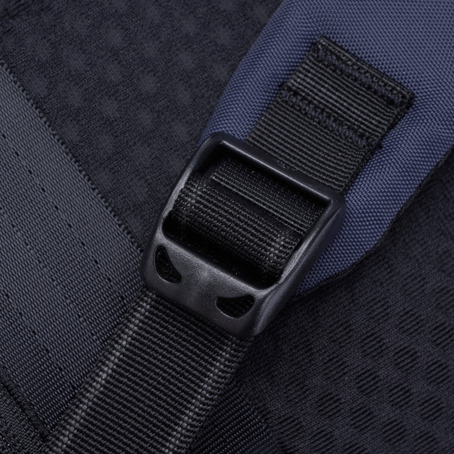 Close-up of a black strap with plastic buckle on the Pacsafe V 16L Anti-theft Backpack.