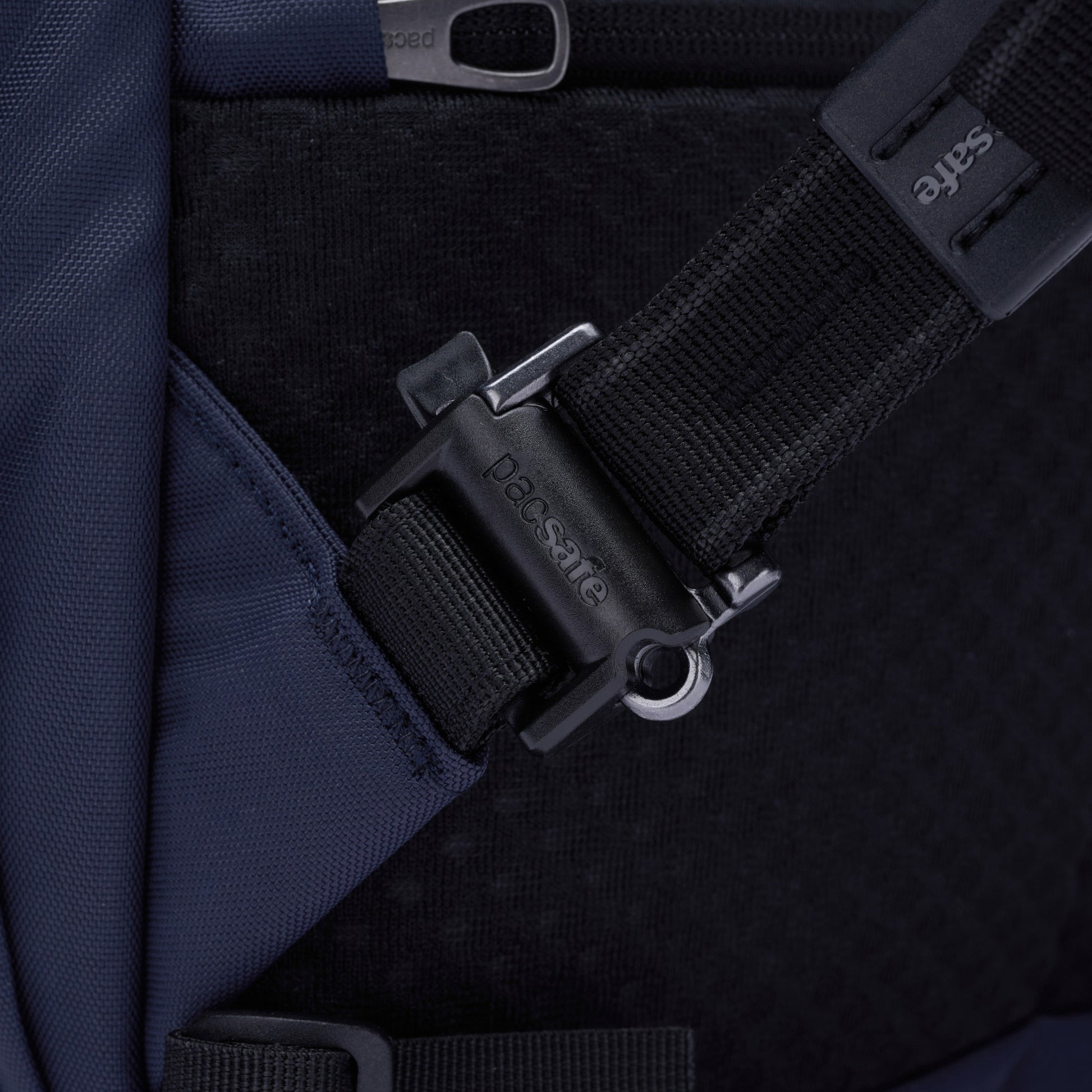 Close-up of a Pacsafe ocean backpack strap with black security buckle.