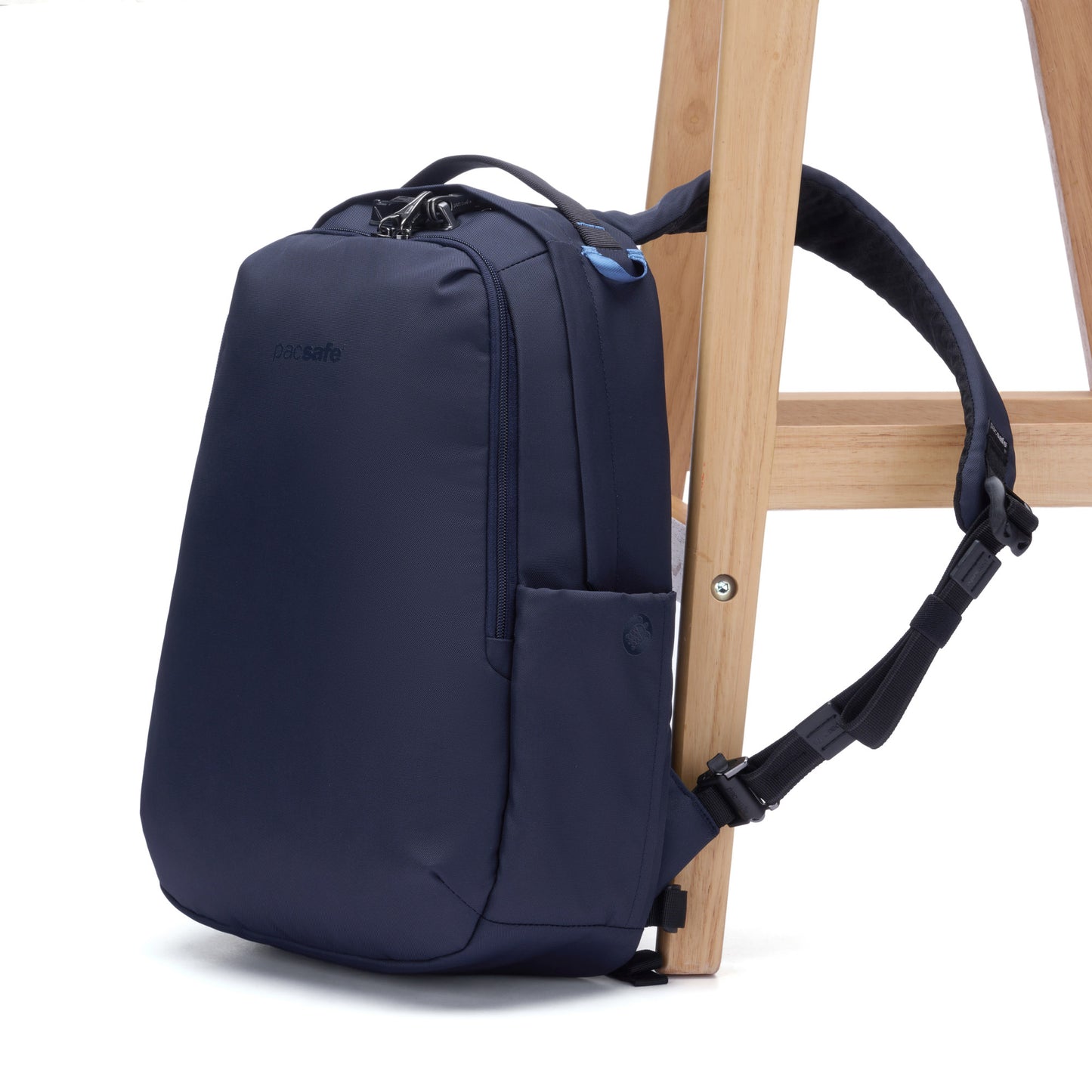 The Pacsafe® V 16L anti-theft backpack in ocean, strapped to a chair leg.