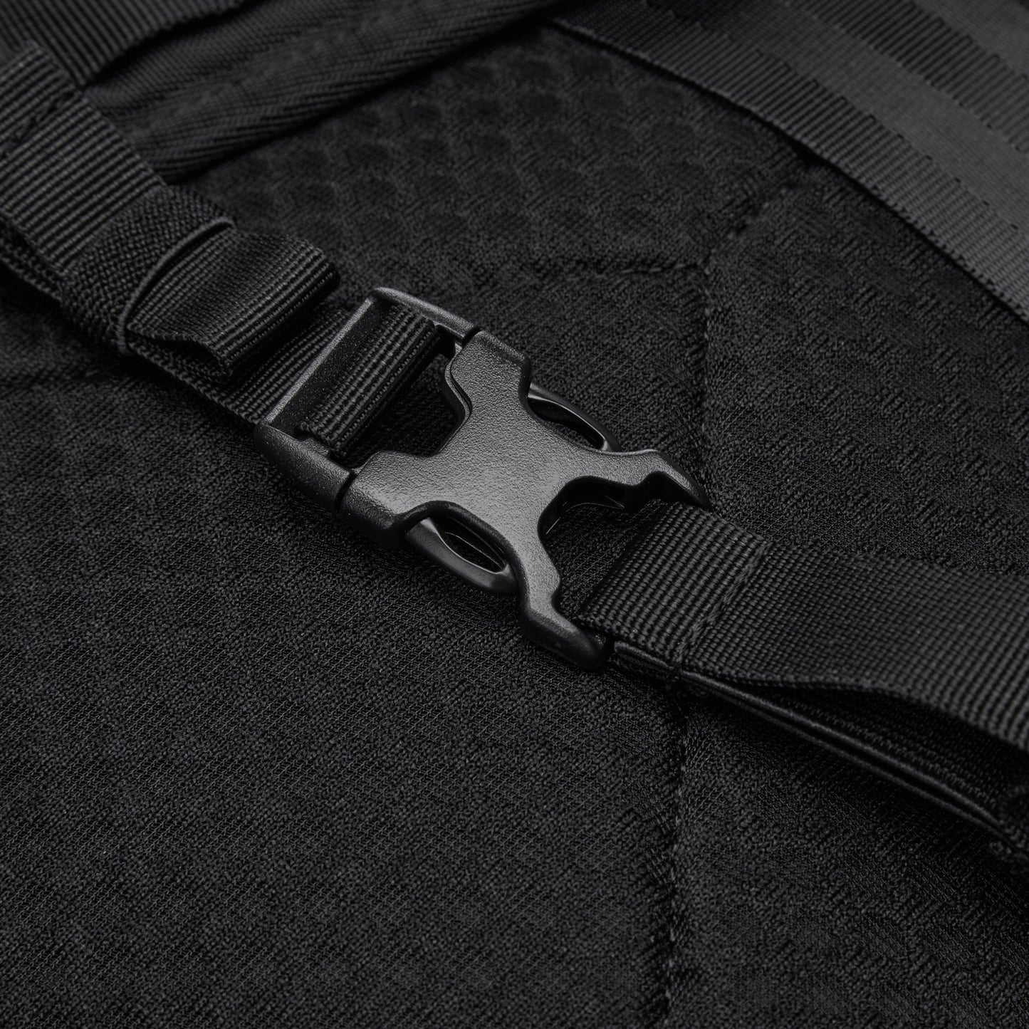 Close-up of a black buckle fastened on a recycled polyester strap on the Pacsafe® V 24L Anti-theft Active Backpack.
