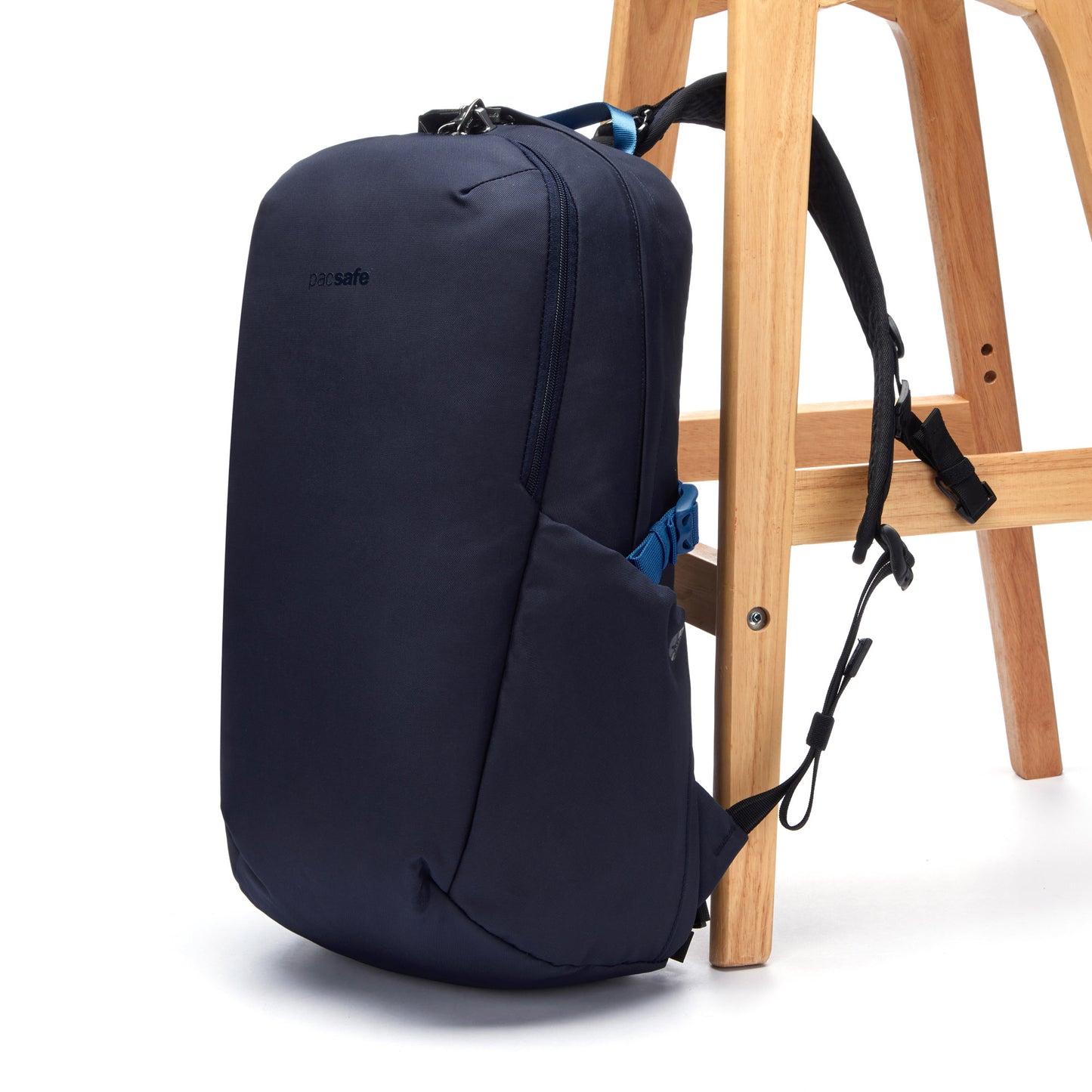 Pacsafe® V 24L Anti-theft Active Backpack with laptop sleeve, from recycled polyester, attached to a wooden stool leg.