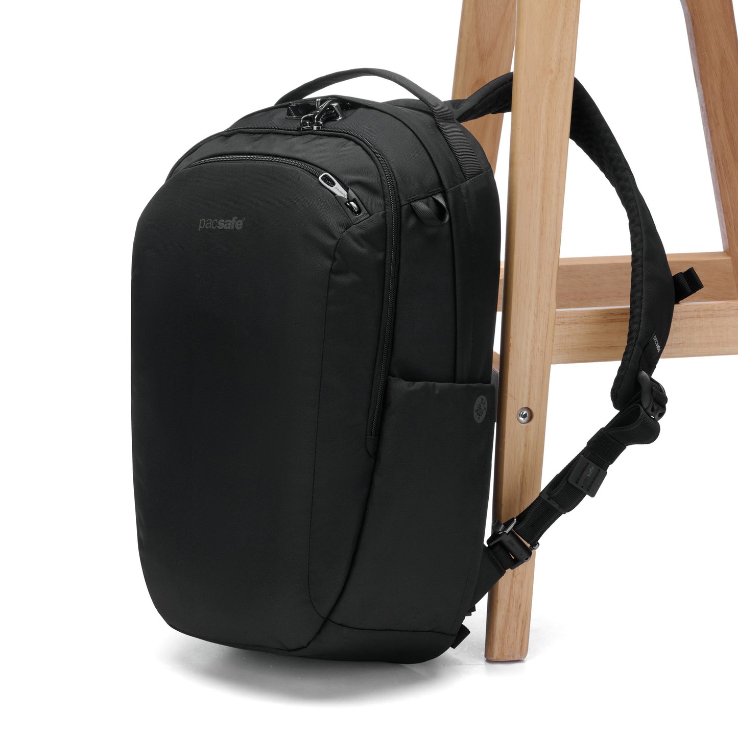 Pacsafe® V 26L Anti-theft Tour Backpack in black, secured to wooden chair leg.
