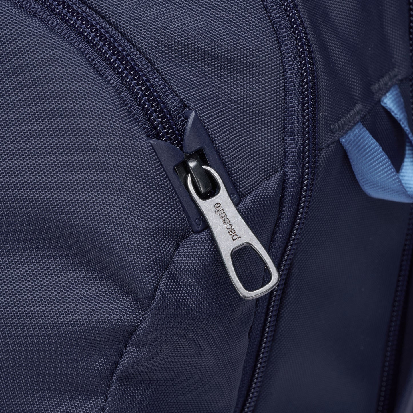 Close-up of the Pacsafe® V 26L Anti-theft Tour Backpack's navy zipper with a metal pull tab.
