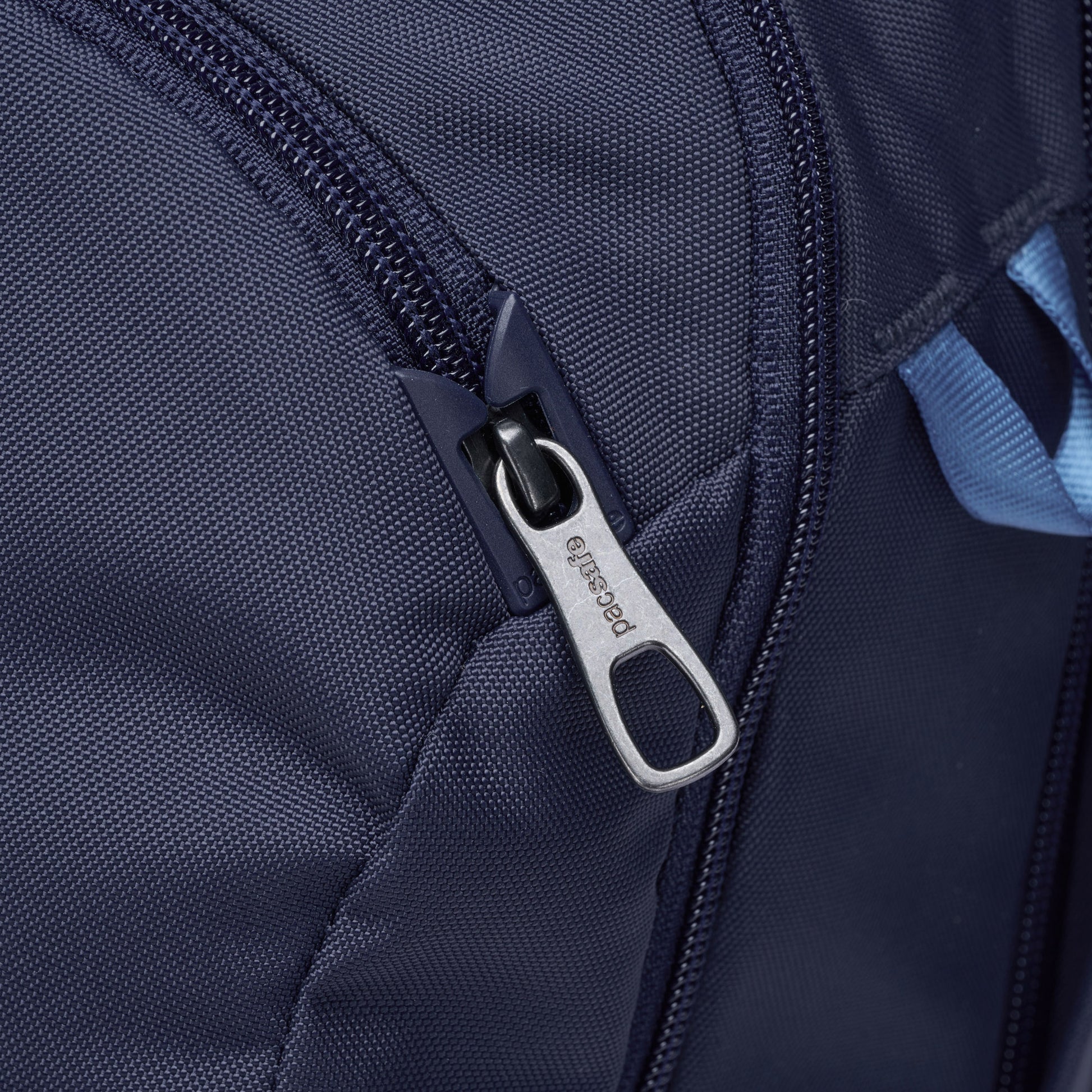Close-up of the Pacsafe® V 26L Anti-theft Tour Backpack's navy zipper with a metal pull tab.