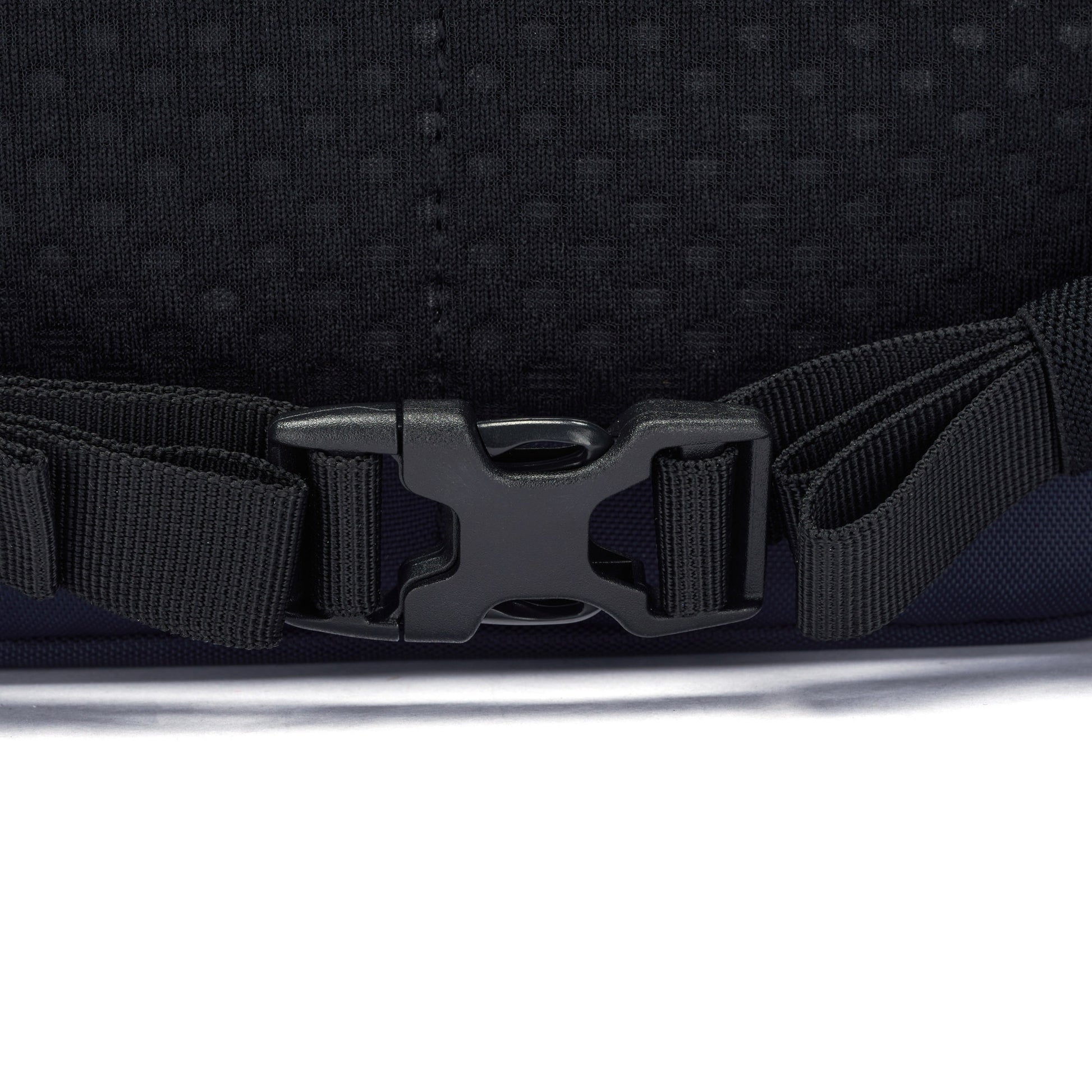 Close-up of a black buckle on a strap, clipped together on a Pacsafe® V 26L Anti-theft Tour Backpack.
