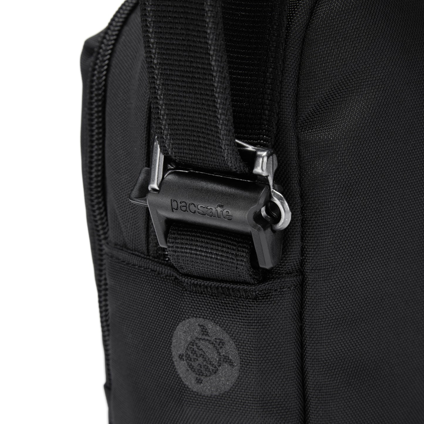 Close-up of Pacsafe® V Crossbody's strap with "Pacsafe" metal buckle, turtle logo, and anti-theft design.