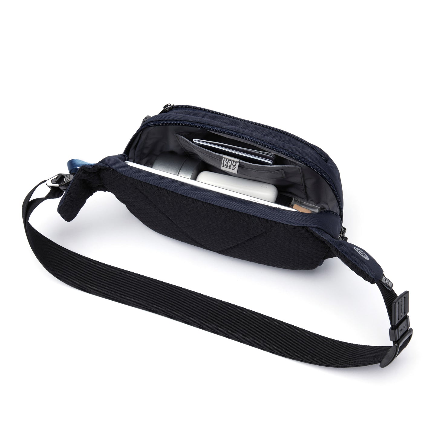 Pacsafe® V anti-theft hip pack in ocean blue unzipped with passport, phone and several accessories packed inside.